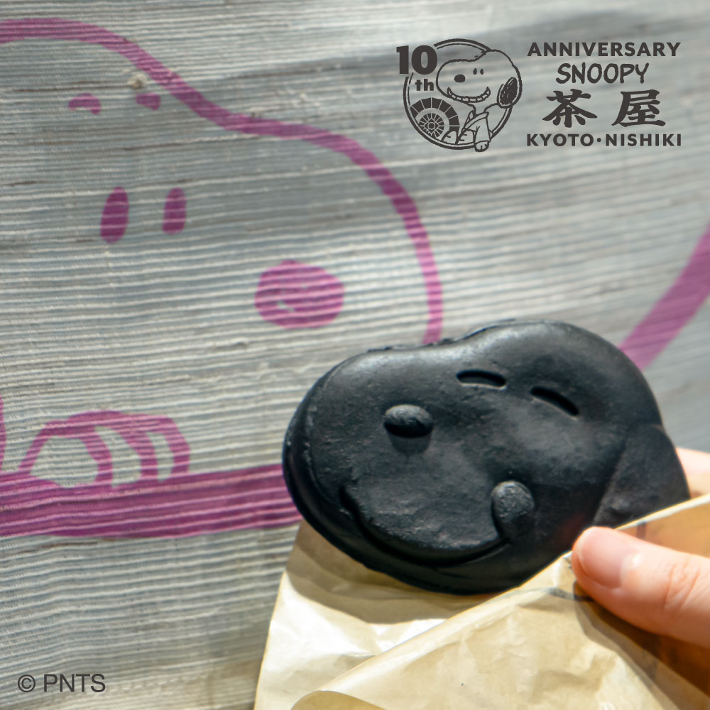 Snoopy_chaya's tweet photo. 本日8月1日(土)より #SNOOPY茶屋 京都・錦店の開店10周年を記念して新商品やノベルティ、記念メニューなどがスタート！

一部ご紹介♪

京都・錦店10周年記念[漆黒のスヌーピーやき]はテイクアウト限定で販売。
2F #WOODSTOCKNEST にはイートインスペースもあり、ちょっとした休���にもおすすめです♪

さらに、10周年を機に、錦市場にゆかりを持つ画家：伊藤若冲の作品と、PEANUTSのアートがコラボレーションした特別なデザインの商品も登場！
今の時期にぴったりな竹うちわや、コレクションしたくなるアイテムなどをご用意しています。
そのほかにも、京和傘を持ったかわいいスヌーピーのマスコットや、錦市場の魅力をぎゅっと詰め込んだ新商品が盛りだくさん♪

そしてご来店いただいた際は、10周年を記念した来店記念スタンプもお忘れなく！

皆さまのご来店を心よりお待ちしております。

#snoopy #peanuts #スヌーピー茶屋 #錦店 #10周年 #スヌーピーグッズ #史努比 #花生