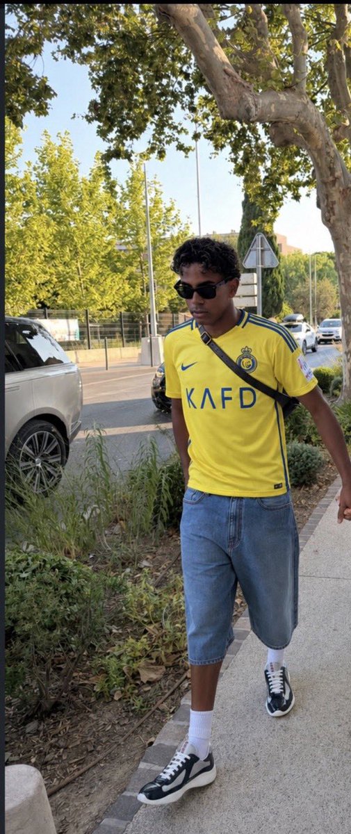 ANassr11's tweet photo. لامال لاعب برشلونة وبطل كأس العالم يرتدي شعار العز والفخر النصر السعودي في شوارع اسبانيا 💛 https://t.co/4OevgUI24P