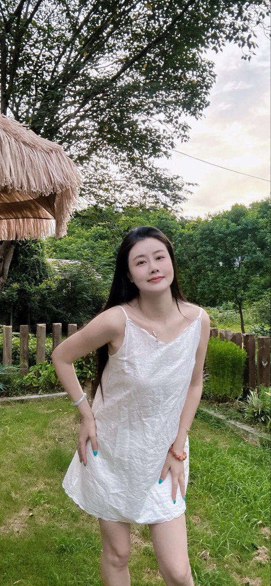 wangxifeng1986's tweet photo. 虽不见碧海惊涛，却邂逅了海边营地般的惬意时光。
白色吊带裙，踩一双运动鞋，在茅草伞下闲坐，任海风穿过绿茵。木栅栏围起一方静谧，草地上光影斑驳，远处树影婆娑如浪。不必追逐潮汐，就这样瘫在露营椅上，听风吟、看云舒，把夏日的慵懒都泡进这慢悠悠的午后。海边度假的真谛，原是让心彻底放松。 https://t.co/xL6azefqDB