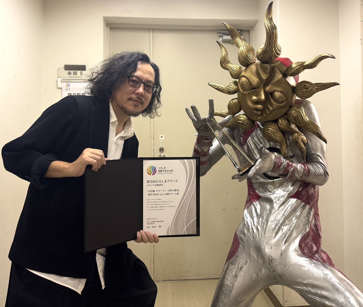 eiga_taroman's tweet photo. 第３回「ひろしまアワード」にてメディア芸術部門を受賞した『大長編 タローマン 万博大爆発』藤井亮監督および制作チームが授賞式に参加しました！

#タローマン も登場し、会場で大あばれ！

すばらしい賞をいただき、ありがとうございます！

⭐️8/20には受賞を記念して、
#応援してはいけない応援上映 開催！

声出し、鳴り物、グッズ、コスプレ🆗！
再びタローマンが広島で大あばれする、なんだこれは！な劇場体験へぜひお越しください！

🎫チケット購入はこちらから！
https://t.co/qBmoLdQOpZ
※「8/20（木）1日券」もしくは「全日程通し券」をお申込ください。