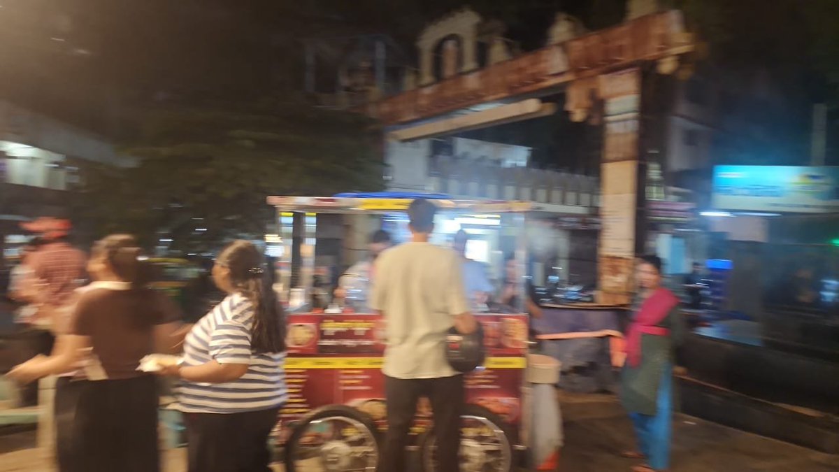 SaveBasavangudi's tweet photo. #GandhiBazaar #Basavanagudi 

Night time, footpath fully occupied by carts, food stalls, people crowding. Pedestrians are forced to walk on the road. Tactile tiles for visually impaired are also blocked. 
Despite HC/SC orders on clearing footpaths, enforcement looks missing here.

Why "no action" keeps happening - 3 ugly reasons people talk about:
"Freedom to Encroachment": Vote bank politics. Every cart = 1 family. Before elections no one wants to touch it.
Money trail: Yes, "Is footpath rented out?" is the question everyone asks. Monthly "hafta" to local staff makes removal temporary?? 
Stalls come back in 2 days.

Lack of coordination: GBA says "Police duty". Police says " hawker zone". GBA
 marshals say "no staff". Result = Public suffers.

- GBA officials not worried about public safety. Senior citizens, kids, disabled people can’t use footpaths at all.

 If a fire/ambulance comes, this crowd blocks it.
