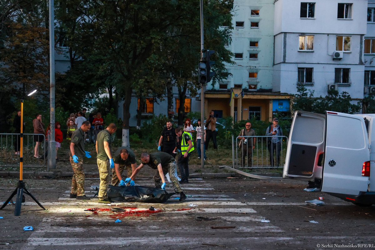 SerhiiNuzhnenko's tweet photo. На вулиці в Дарницькому районі, на проміжку завдовжки 300 метрів сьогодні загинули сім людей. СІМ ЛЮДЕЙ.

На тротуарі лежало тіло молодого патрульного, який допомагав людям на місці першого удару. Під час другого удару він загинув. Його тіло лежало під прожектором, над ним тримали білий поліетиленовий мішок для тіл, у який за мить його покладуть. Цей мішок  світився у світлі прожектора, і здавалося, що це мертвий ангел і його крила, які йому вже не потрібні.

На пішохідному переході лежали два розірвані тіла. Люди бігли до укриття, але вирва від балістичної ракети за 20 метрів не дала їм жодного шансу.На протилежній стороні вулиці, за червоною стрічкою стоять люди, діти які можливо знали загиблих. Дехто плаче.

За п’ять метрів від входу до укриття лежить ще одне тіло. Воно накрите. До нього скоро підійдуть працівники поліції, опишуть місце, де людина загинула, перевірять тіло на наявність документів, покладуть його в поліетиленовий мішок для тіл , а потім завантажать до білого «буса», де вже лежать такі самі мішки з тілами людей. П’ять метрів для світу — це така мала відстань, але саме цих п’яти метрів людині не вистачило, щоб залишитися живою.

На дорозі стоїть авто. Воно повністю згоріло, ще йде легка пара від води, якою його гасили рятувальники. Авто все як решето. Схоже , удар був завданий ракетою з касетною бойовою частиною Поліцейські в блакитних  рукавичках дістають з авто те, що залишилося від людини. Ось дістали обгорілу чорну частину ноги.

Ще декілька тіл лежать неподалік. На пішохідному переході, де загинули дві людини, великі плями червоної крові. Зі сходу в цей час починає жевріти червонуватий схід сонця.

У Києві сьогодні вбили дев’ятьох людей. Вбили в центрі Європи, у час, коли люди планують політ на Марс. Вбили тому, що вони були українцями. Назвати вбивць не можна, тому що ця соціальна мережа вважає це «мовою ворожнечі».

Працюючи на місцях, подібних до сьогоднішнього, я багато разів чув від людей лише кілька слів: «Будьте ви прокляті, підари». У цьому світі майже немає справедливості. То, може, вона є в іншому світі?

Будь ласка, коли вже балістика вибухає в місті, не потрібно бігти на вулицю до укриття. Бо саме на вулиці ви можете потрапити під уламки.

За останніми даними, сьогодні в Києві загинули дев’ятеро людей, ще 28 дістали поранення, серед них четверо дітей. Сухі статистичні слова, за якими були живі люди з іменами і мріями