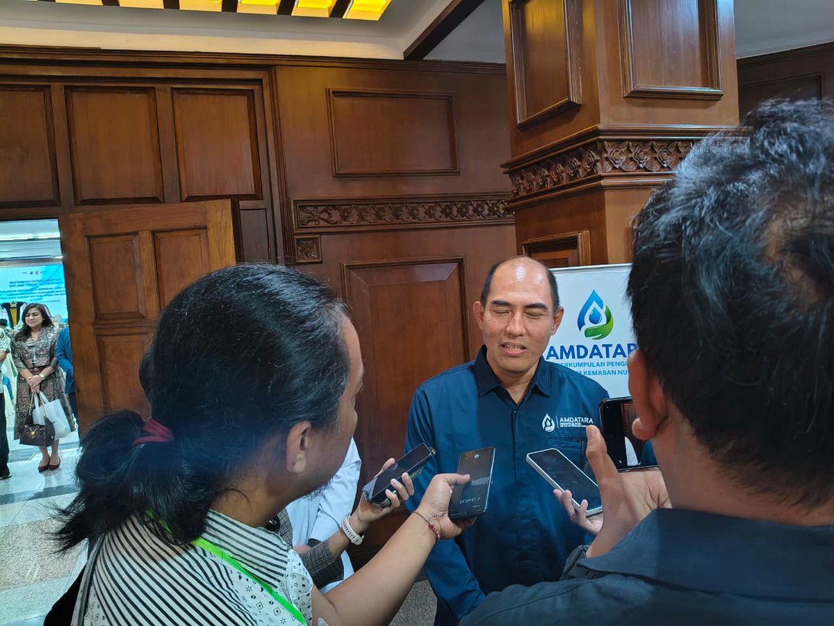 amdatara's tweet photo. Ketua Umum DPP AMDATARA, Karyanto Wibowo, menyampaikan bahwa Jawa Tengah memiliki posisi yang sangat strategis dalam perkembangan industri AMDK nasional. Dengan sekitar 131 perusahaan yang beroperasi di wilayah Jawa Tengah, provinsi ini menjadi salah satu basis industri AMDK terbesar di Indonesia dan memainkan peran penting dalam penyediaan air minum yang aman dan berkualitas bagi masyarakat.  Menurut Karyanto, pengukuhan pengurus baru bukan sekadar agenda organisasi, tetapi juga langkah penting untuk memperkuat kontribusi industri terhadap pembangunan daerah. Ia menegaskan bahwa ke depan AMDATARA akan terus mendorong sinergi yang lebih erat dengan pemerintah, memperkuat kepatuhan terhadap regulasi, serta mengembangkan berbagai program keberlanjutan yang memberikan manfaat bagi masyarakat dan lingkungan.  “Pengurus baru akan memperkuat sinergi dengan pemerintah, menjaga kepatuhan regulasi, serta mendorong konservasi air dan pengelolaan kemasan pascakonsumsi. Tugas utama kami adalah menjaga keberlanjutan sumber daya air, mengembangkan ekonomi sirkular dan daur ulang kemasan, memperkuat kepatuhan terhadap standar mutu produk, serta membangun kemitraan strategis dengan berbagai pemangku kepentingan,” ujar Karyanto.  Ia juga menjelaskan bahwa AMDATARA yang berdiri pada tahun 2025 kini telah berkembang menjadi wadah bagi lebih dari 100 perusahaan dengan lebih dari 200 merek AMDK di Indonesia. Karena itu, AMDATARA berkomitmen tidak hanya mendorong pertumbuhan industri, tetapi juga memastikan bahwa pertumbuhan tersebut berjalan seiring dengan pelestarian lingkungan.  “Bagi kami, AMDATARA bukan hanya tentang industri. Kami ingin menjadi bagian dari solusi. Semangat kami adalah ngelakoni lan ngopeni Jawa Tengah—bertumbuh bersama masyarakat sekaligus menjaga sumber daya alam agar tetap lestari bagi generasi yang akan datang,” tambahnya.
#amdatara #musda #AMDKnusantara #airmunumdalamkemasan