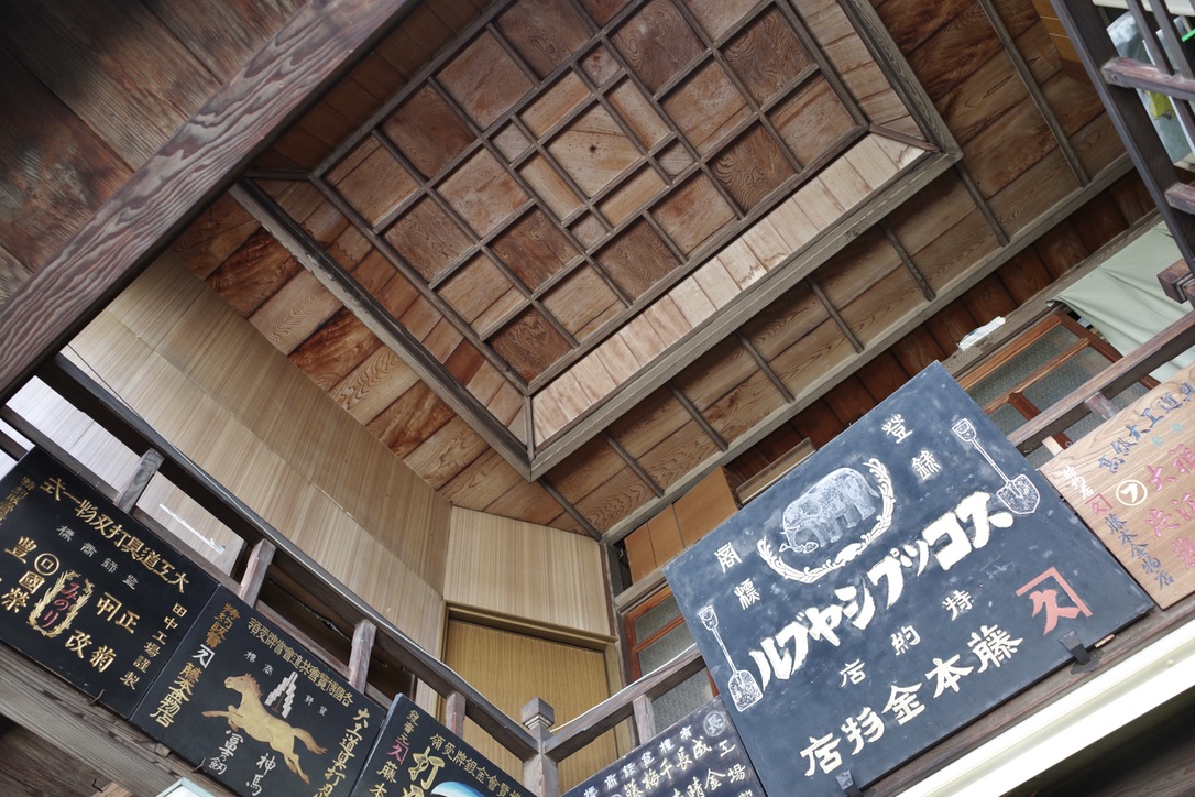 nori7770's tweet photo. 煉瓦の防火壁を持つ金物屋さん、店内に入って吹き抜けを見上げると素敵な木製看板と格天井があった https://t.co/FH6wAsFrjz