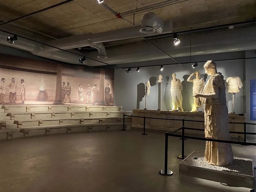 Lucius_Gellius's tweet photo. Une statue en marbre de 2,7 mètres de haut représentant la déesse Hestia, découverte en 2 parties en 2005 lors de fouilles sur le site antique d'Aigai, dans l'ouest de la Turquie, est présentée au public un nouveau musée de Manisa ouvert en 2025 créé à cet effet. 

Elle est considérée comme la seule statue d'Hestia de la période hellénistique connue à avoir survécu jusqu'à nos jours. 

Hestia est la déesse protectrice vénérée des foyers et des villes dans la religion grecque antique . 

Chez les grecs, les statues d'Hestia étaient couramment placées dans les édifices du conseil (bouleuteria), symbolisant l'ordre civique et l'unité. 

Comme l'explique le professeur Yusuf Sezgin, directeur des fouilles d'Aigai et professeur d'archéologie à l'université Celal Bayar :

« Dans l’Antiquité, les décisions du conseil étaient prises en regardant Hestia droit dans les yeux. Elle incarnait l’unité, la stabilité et la boussole morale de la cité. »

La salle du musée qui accueille la statue reproduit l'agencement architectural de la salle du conseil originelle d'Aigai aux côtés d'autres statues honorifiques découvertes sur le site.

Située en Turquie occidentale, Aigai était l'une des douze cités antiques de la Ligue éolienne. Fondée dès le VIIIe siècle avant notre ère, la ville connut son apogée architectural et politique durant la période hellénistique.

Construite sur un terrain montagneux, Aigai présente des édifices publics exceptionnellement bien conservés, notamment un bouleutérion (maison du conseil) , une agora , un théâtre , des portiques,  des temples...