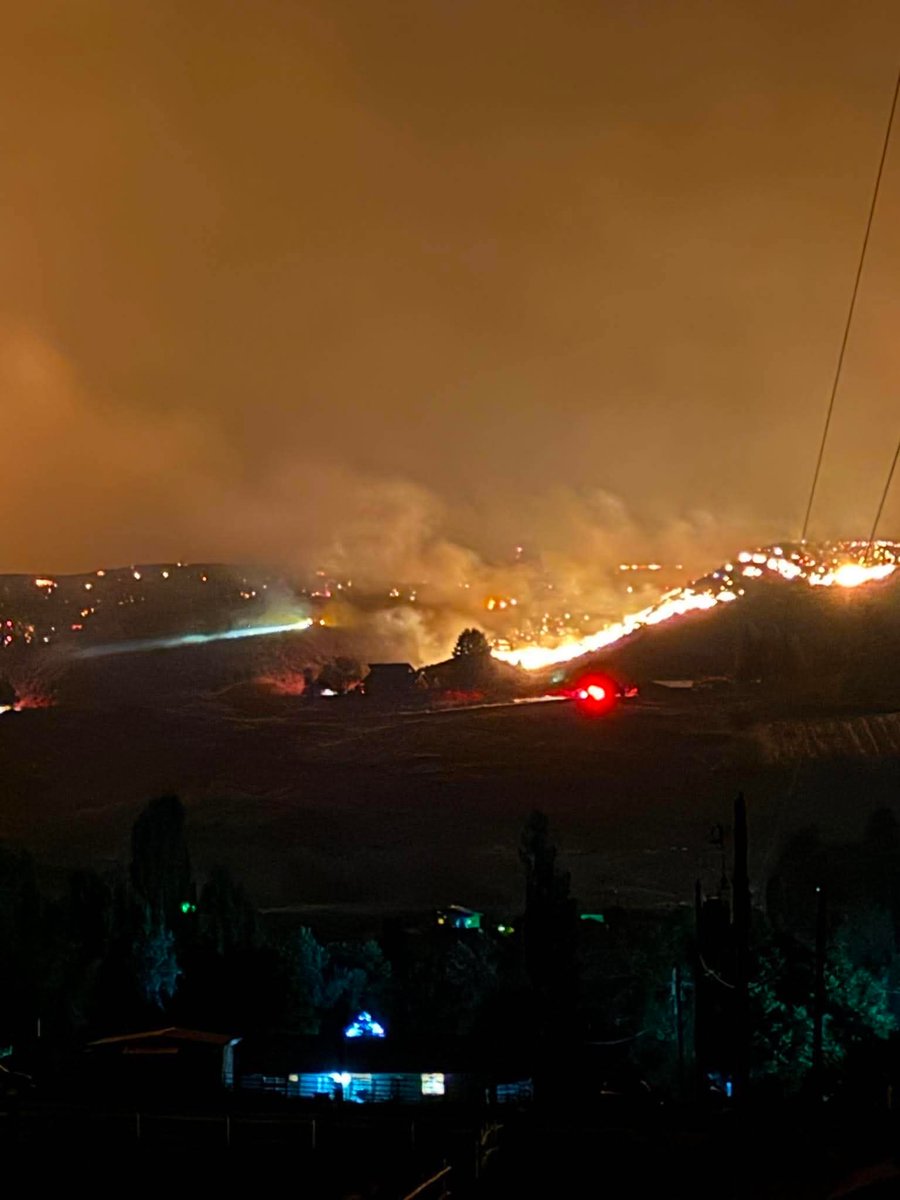 Bellingham_News's tweet photo. UPDATE: New photos show Sinlahekin Fire moving closer to Tonasket overnight

New images shared with Bellingham Metro News by Tuesday McAllister show the Sinlahekin Fire continuing to burn along the hillsides overlooking Tonasket as firefighters work through the night to slow its advance.

The latest photos capture long stretches of active fire, heavy smoke and glowing ridgelines just outside the community, highlighting how close the wildfire has come to populated areas. The fire’s glow can be seen from neighborhoods near the city as conditions remain dangerous.

Evacuation orders remain in effect for parts of the area, and officials continue urging residents to stay alert and follow all emergency instructions as the situation evolves.

Bellingham Metro News will continue providing updates as more information becomes available.

Photos courtesy of Tuesday McAllister, shared with permission.