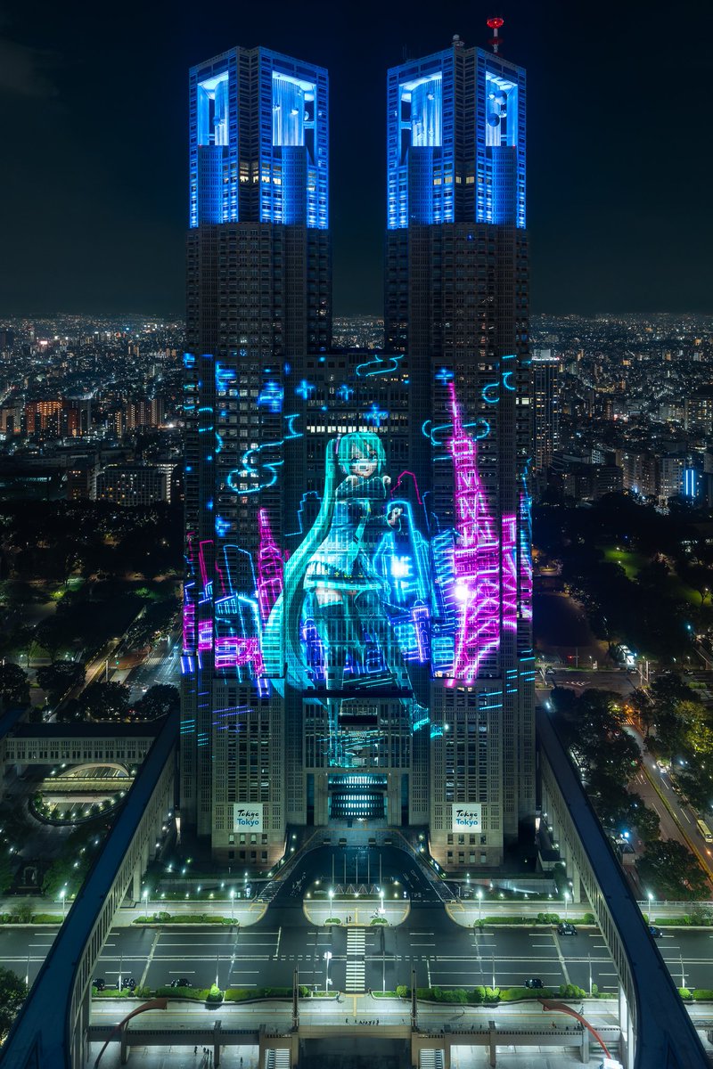 yumeka's tweet photo. 東京の夜景に、電子の歌姫が舞い降りる。
都庁で7末から初音ミクのプログラムが週末に限り再上映中。
45周年を記念して始まったパックマンの方も、あわせて撮ってきました https://t.co/bWbEwSGsA6