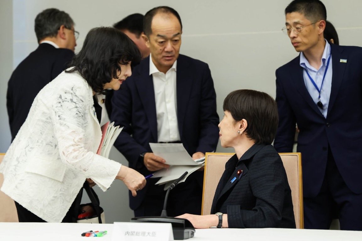 cobta's tweet photo. 高市首相がつくらせた内閣広報アカの写真の特徴に、いわゆる映えだけでなく、「上下のわからせ」と「忙し感の演出」があります。高市首相は腰かけたまま他の閣僚に返事をしており、視覚的に「身分の上下」を伝えます。人が出入りしていることを伝えるために、複数人の男女が前後を囲む構図が多いです。 https://t.co/mMvVLWmWZL