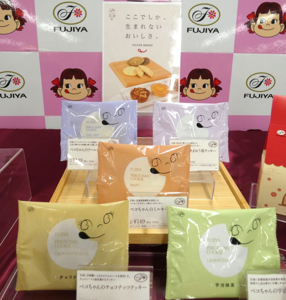 shokuhinet's tweet photo. 不二家は不二家洋菓子店で新焼菓子シリーズを8月1日に発売開始した。

　新焼菓子は、既存焼菓子約20品のうち一部商品との差し換えで計12品をラインアップ。
　内訳は8月1日発売のタルト6品とクッキー5品に加えて、8月7日に新発売する「ひだまりペコちゃん」の計12品。

　7月31日、プレス試食会で商品企画を担当した洋菓子事業本部営業本部マーケティング部営業推進課の三井咲良氏は「『不二家でしか、生まれないおいしさと。』をキャッチコピーに新焼菓子シリーズを立ち上げた」と語る。

　不二家らしさを詰め込む開発には約3か月を要した。12品の開発を手掛けた野木工場製品開発課の宗川彩子氏は「全て不二家洋菓子店以外のお店にはないものとなる。『ミルキー』をモチーフにしたものを食べたかったら不二家に来るしかない」と胸を張る。

　不二家では、菓子と洋菓子を別々に展開するのではなく、菓子の強みを洋菓子にも活かしていく方針を掲げている。

　この方針を具現化した「ミルキータルト」は、タルト生地に「ミルキー」風味のペーストと「ミルキー」と同じ北海道産れん乳を使用したフィリングを重ねて焼き上げた二層仕立てのタルト。

　これに対して「カントリーマアムタルト」は一層仕立てでタルト生地に細かく砕いた「カントリーマアム」風のクッキーを練り込み「カントリーマアム」の複雑な風味や味わいを忠実に再現したものとなる。

　渦巻き模様のソフトキャンディ「ノースキャロライナ」をイメージしたタルトも開発。そのほか、創業以来支持を得ている「モカケーキ」のタルトや、ソフトな食感を生まれ変わった「不二家 アーモンドタルト」を取り揃えている。

　新食感のタルトとしては、じゃがいもフレークを練り込んだタルト生地に、茨城県産紅あずまペーストを使用したフィリングを重ねて焼き上げた「あずまると」を発売している。

　クッキーは、しっとり食感の「ペコちゃんのクッキーシリーズ」として全5種類をラインアップしている。

　8月7日に新発売する「ひだまりペコちゃん」は、卵を多く使用した、はちみつが香る生地をふんわりと焼き上げたやさしい味わいのマドレーヌ。「1歳以上の小さなお子様のおやつとして安心してお召し上がりいただけるおやつ菓子」（三井氏）と述べる。 #不二家 #菓子 #洋菓子 #クッキー #カントリーマアム #タルト #ミルキー #ペコちゃんのクッキーシリーズ #焼菓子