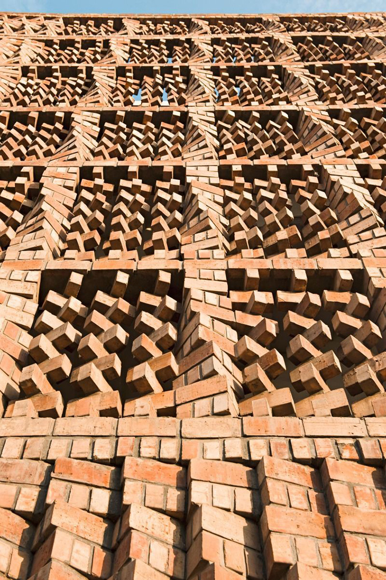 archpng's tweet photo. This seemingly chaotic brick facade was built from a carefully calculated six-brick module.

Designed by Anagram Architects for the South Asian Human Rights Documentation Centre in New Delhi, the screen uses staggered and rotated bricks to create an undulating, porous surface. It provides shade, ventilation, and visual and acoustic privacy from the busy street outside.

The unusual masonry system was developed directly on site over five weeks, with custom wooden wedges helping bricklayers position each course at the correct angle.

Completed in 2005, the building fits approximately 1,850 square feet (172 m²) of workspace onto a site measuring just 538 square feet (50 m²).

South Asian Human Rights Documentation Centre
Anagram Architects — New Delhi, India
 Photography: Asim Waqif