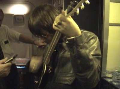 oasisvaults's tweet photo. liam playing a pignose guitar on the plane, March, 2000. https://t.co/yTOooo7jJG