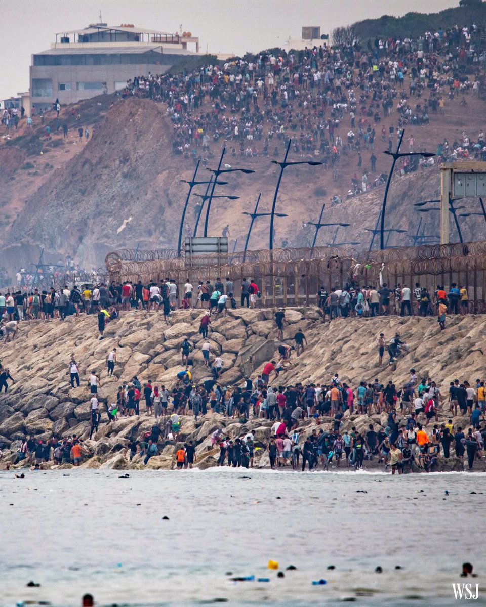 sentdefender's tweet photo. Spain is facing its most serious migration crisis in years after a mass surge into the North African enclave of Ceuta left at least 72 people dead and reignited debate over European border security.

According to Spanish authorities, more than 50,000 people attempted to enter Ceuta from Morocco by land and sea, overwhelming local resources. While the vast majority have since returned to Morocco, Spanish officials continue to recover bodies, reinforce the border, and investigate the role of human smuggling networks and online misinformation in fueling the surge.

The crisis has prompted a broader European response. Twenty-two EU member states have called for stronger external border protections, Spain has installed a 500-meter floating sea barrier off Ceuta, and Italy temporarily reinstated border controls with Spain, citing security concerns.

Until this incident, Spain had actually experienced a decline in irregular migration during 2026. Through the end of June, 12,138 migrants had entered Spain irregularly; 32% fewer than during the same period in 2025. Arrivals to the Canary Islands were down sharply, while land crossings into Ceuta and Melilla had already increased by more than 150% year-over-year, foreshadowing mounting pressure along Spain's North African land border.

Image: Wall Street Journal