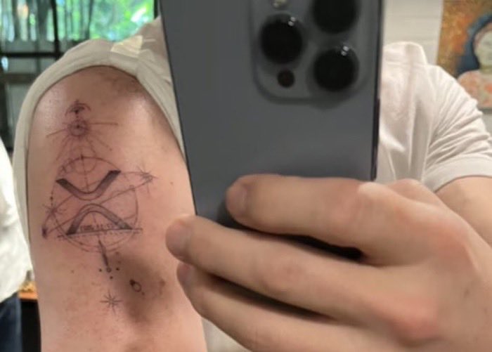 Stellar_Rippler's tweet photo. A very interesting day is approaching for Brad Garlinghouse’s XRP Tattoo

August 12, there is a total solar eclipse, active meteor shower, and six planets in a straight line.

Brad’s tattoo isn’t just a drawing.
07.13.2023 = the day Judge Torres ruled XRP is not a security.

XRP logo ringed by Saturn (mentioned in bear’s riddles).

Geometric lines = order, connection, global expansion.

He tattooed the end of the old financial system.