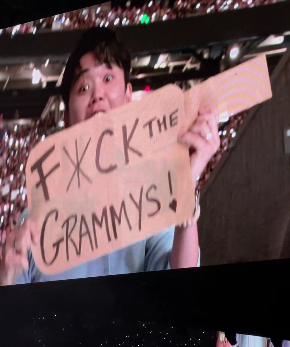 thsweeth's tweet photo. El chico que llevó ayer el cartel de "F*CK THE GRAMMYS" llevó hoy el mismo pero le agregó "AGAIN" JAKAKAJJA IDOLO https://t.co/bRIiFHarlq