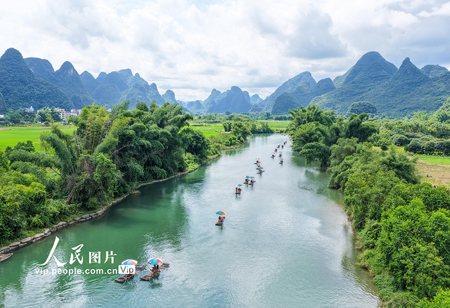 PDChinese's tweet photo. 【廣西陽朔：樂遊山水間】8月2日，廣西桂林陽朔縣遇龍河景區，遊客乘坐竹筏欣賞兩岸秀美風光。 https://t.co/KBJK2LLjig