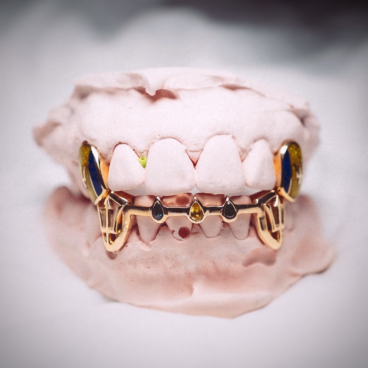 PLYGRNDldn2026's tweet photo. The best custom pieces tell a story. This bespoke set for @deejaypuffy celebrates Barbados through handcrafted details, from the flag to the trident, finished with black diamonds and sapphires for a clean, understated look. 
💛💙

#PLYGRNDLDN #CustomGrillz #HandmadeJewellery https://t.co/Xet2KLw8g7