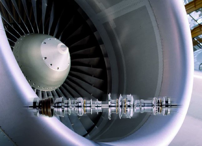 Arkasiraee's tweet photo. A modern commercial turbofan is often celebrated for its fan, compressors, and turbine blades. Yet one of its greatest engineering challenges is almost invisible at its core, keeping multiple rotating shafts, each spinning at different speeds and transmitting enormous power, perfectly aligned for decades. 

That task falls to just 5-8 critical bearing locations precision components some small enough to fit in one hand, yet responsible for keeping an engine worth $40-50 million alive while allowing rotating shafts to survive enormous forces, thermal expansion, and extreme operating conditions.

A modern turbofan is not one rotating machine but several concentric systems. 

The low-pressure spool, which drives the massive front fan, typically rotates at 2,000-4,000 RPM, while the high-pressure core can exceed 10,000-20,000 RPM. 

These shafts rotate independently through specialised ball, roller, thrust, and intershaft bearings, continuously absorbing enormous radial and axial loads while maintaining microscopic alignment. Conventional industrial bearings would rapidly overheat, deform, and fail under these conditions. Aerospace bearings, by contrast, are engineered to survive 20,000-50,000 flight hours, accumulating an estimated 30-70 billion rolling contacts before major overhaul.

The environment makes the challenge even more extraordinary. Only a short distance away, turbine gases exceed 1,500°C, with single-crystal turbine blades surviving through internal cooling channels and thermal barrier coatings. 

The bearings themselves, however, must remain within a much narrower operating window of roughly 120-200°C, with extreme conditions approaching 300°C at peak power. 

This is achieved through sealed bearing compartments, compressor bleed-air cooling, and sophisticated lubrication systems that maintain a protective oil film typically only 1-5 micrometres thick around twenty times thinner than a human hair while continuously carrying heat away from the bearing. If that microscopic film breaks down, metal-to-metal contact can occur almost instantly, rapidly leading to catastrophic jet engine failure in seconds. 

The bearings themselves are built from materials far beyond conventional engineering steels. Aerospace manufacturers use specialised alloys such as M50 and M50NiL bearing steels, chosen for exceptional hardness, fatigue resistance, and high-temperature strength, while many modern engines incorporate silicon nitride ceramic rolling elements that are around 60% lighter than steel. 

The reduced mass significantly lowers centrifugal forces at high rotational speeds, allowing higher operating limits with less friction, lower heat generation, and longer fatigue life.

Manufacturing these components is a discipline of its own. The steel undergoes vacuum melting, remelting, precision heat treatment, grinding, and superfinishing to eliminate microscopic inclusions that can become fatigue cracks after billions of cycles. 

Final dimensional tolerances are measured in microns, while raceway surface finishes approach nanometre-scale precision. Producing the bearing is only half the challenge, every aerospace design must then survive years of fatigue testing, thermal cycling, overspeed testing, and certification before it is approved for commercial flight.

Companies such as Timken, NTN Corporation, and NSK  are among the global leaders. A conventional industrial bearing may cost $100-1,000. By contrast, large aerospace mainshaft bearings are widely estimated to cost $30,000 to well over $140,000 per bearing once aerospace-grade materials, precision manufacturing, inspection, and certification are included. Their value lies not in their size, but in the fact that a single bearing failure can destroy an engine worth tens of millions of dollars and risk the lives of hundreds of people onboard. 

Jet engines are often associated with combustion, compressors, and turbine blades. In reality, none of those technologies could operate for more than moments without a handful of aerospace grade precision bearings quietly controlling friction, heat, and fatigue at the very limits of metallurgy.