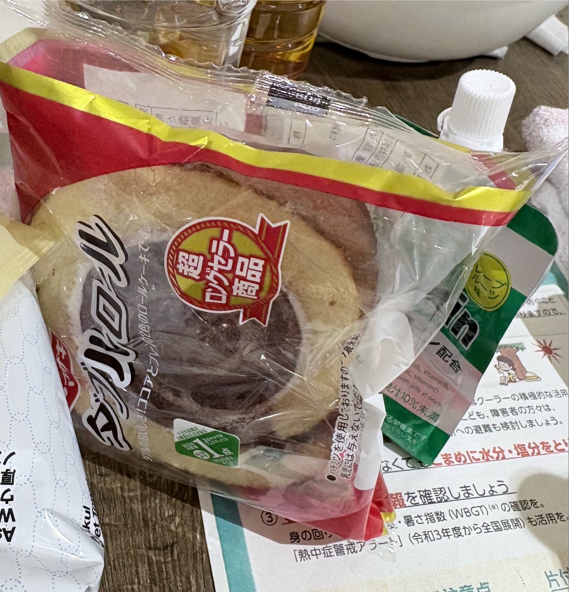 kogaryoko's tweet photo. この段ボール一枚の上で、おばあちゃんたちは6日間寝ています。
松橋西防災拠点センターに避難している90歳のおばあちゃんが、「お米が食べたい、魚の煮付けが食べたい、でも贅沢よね…」と泣いていました。
きょうの昼ごはんは菓子パンひとつとゼリー飲料。毎食、菓子パン。
炊き出しが行われているのはごく一部。
これが2026年の熊本地震の避難所の現実です。

車で5分走れば、写真のようにお惣菜が売っているお店が再開してるのに、その情報が入らない。暑すぎて自力では移動もできない。
足りないのは移動手段と情報とマンパワーです。
物資は拠点に集まっているのに、そこから配る人材と足がない。

道路も空路も新幹線も再開していて、スムーズに被災地に入れます。
ボランティアの方が今こそ必要だと心から感じました。
#熊本地震