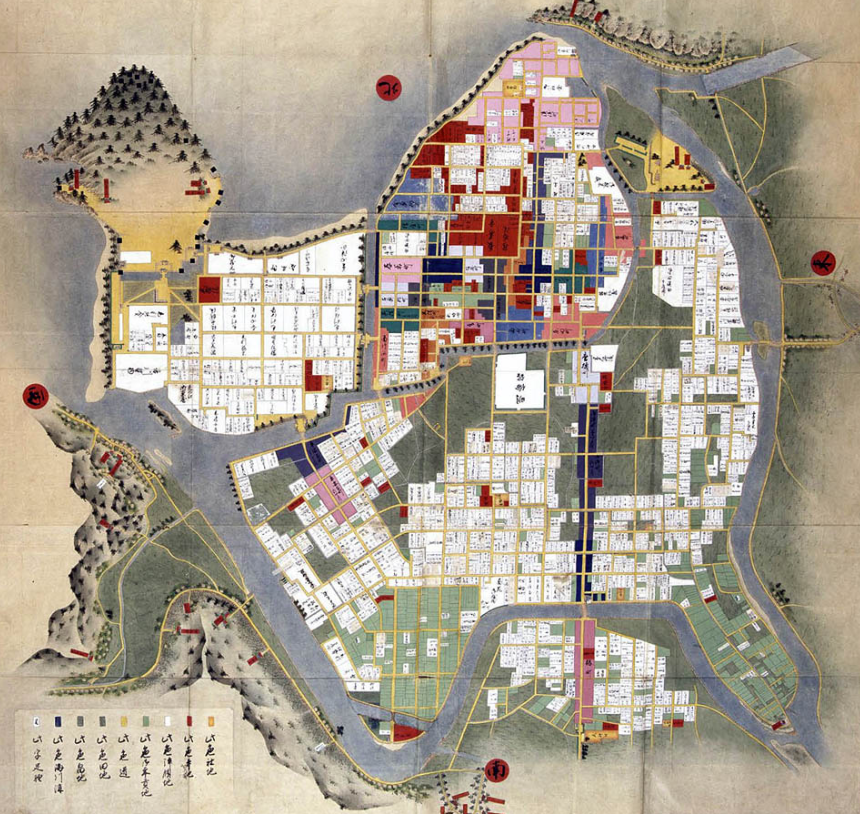 fudosandannaaaa's tweet photo. 萩（長州37万石）：古地図が使える町

萩は「古地図を片手に歩ける町」と案内される。実際、市がその名前でまち歩きの企画をやっている。江戸時代につくられた絵図を持って歩いても、道がそのまま通じるからである。

まず、定番の一枚から始めたい。菊屋横丁である。

城の東にひろがる旧町人地を、二百五十メートルほど南へ抜ける小路だ。白いなまこ壁が続き、日本の道百選にも選ばれている。萩の観光写真といえば、たいていこの一本が出てくる。

その隣に、江戸屋横丁がある。もう一本、伊勢屋横丁がある。この三つの名前は、そのまま江戸時代の萩のショッピングストリートでもある。

東西に走る表通りを御成道といった。城の門を出た殿様が、参勤交代で江戸へ上るとき、この道を通って城下を抜けていく。町人地の背骨であり、公の道でもあった。

その通りに面して、藩の御用達をつとめた豪商が三軒、店を構えていた。菊屋、江戸屋、伊勢屋。表通りから南へ入る三本の小路には、その屋号がそっくり残ったのである。

つまり観光案内に並んでいる横丁の名を読むだけで、江戸の商人がどこに店を構えていたかが分かる。地名が、商いの配置の痕跡になっている。

名前の並びは、もうひとつ教えてくれる。三本とも、御成道から「南へ入る」ということだ。東西に太い背骨が一本あり、そこから枝が南へ伸びる。萩の町人地はそういう組み立てだった。

その菊屋横丁沿いに、高杉晋作の誕生地がある。第26代総理・田中義一の誕生地もある。隣の江戸屋横丁には、木戸孝允の生家が残っている。維新の名がこの一帯に集まっているのは偶然ではない。ここが城下でいちばん人と物の密度が高い場所だったからである。萩の中心地と言っていい。

では、なぜこれだけのものが残ったのか。

萩の城下は、阿武川（あぶがわ）が河口で二手に分かれてつくった三角州の上にある。西を橋本川、東を松本川が挟み、北は日本海。外へは広がれない。町は、この三角州という器の大きさのまま、三百年を過ごした。

萩に鉄道が開通したのは大正十四年である。しかも線路は、旧城下町を大きく迂回して敷かれた。玉江、萩、東萩。三つの駅は、いずれも三角州の外側、当時の山田村、椿村、椿東村にそれぞれ置かれている。町村合併を進めるために各村へ駅を配ったのだ、という言い伝えがある。線路は、ついに町の中へ入らなかった。

戦災もなかった。城が海へ突き出た指月山にあったため、その周りの上級武家地には、開発の圧力がほとんどかからなかった。

昭和五十一年、堀内と平安古——城の膝元にひろがる武家の町並みが、全国で最初の重要伝統的建造物群保存地区に選ばれた。のちに、北の海へ舟を出した港町・浜崎と、山を越える街道の宿場だった佐々並市が加わる。武家の町、港の町、宿場の町。ひとつの市のなかに、性格の違う四つの町並みが並んで残っている。

平成二十七年には、城跡と武家地と町人地が世界遺産の構成資産になった。

古地図が使えるのは、この町が守ったからでもある。 だがその前に、町を書き換える力が、ついに来なかったからでもある。

出典：萩市／山口県観光連盟／佐藤滋＋城下町都市研究体『図説 城下町都市』鹿島出版会