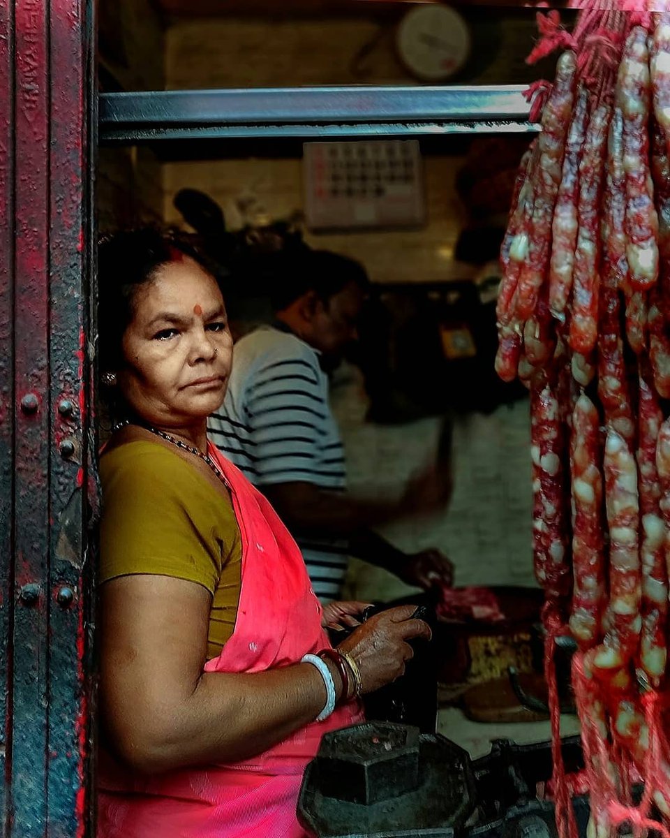arturo_90's tweet photo. Two images from my RED series in Kolkata. Which one do you like more? A Chinese-Bengali woman runs a busy meat shop, embracing change and daily life. The second, my favorite, captures red buildings, a rickshaw, and a homeless person on a winter https://t.co/QMkuMp6IAD