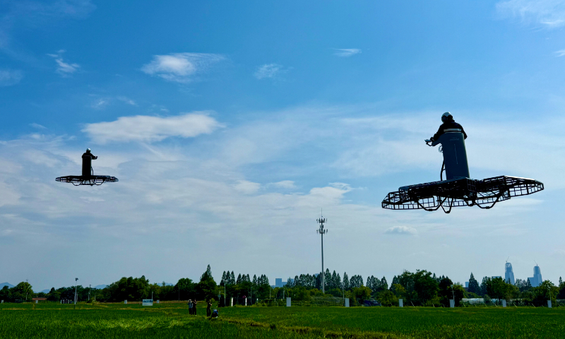 ChinaScience's tweet photo. China has unveiled the world's first standing-position manned flying vehicle, featuring a flat, flower-shaped platform roughly 3.5 meters across, an enclosed-propeller propulsion system, and a central standing area that can accommodate pilots weighing up to 90 kg. Equipped with a dual-redundant flight control architecture and triple-redundant inertial measurement units, the eVTOL aircraft offers a flight time of up to 11 minutes with a 70-kg pilot on board.