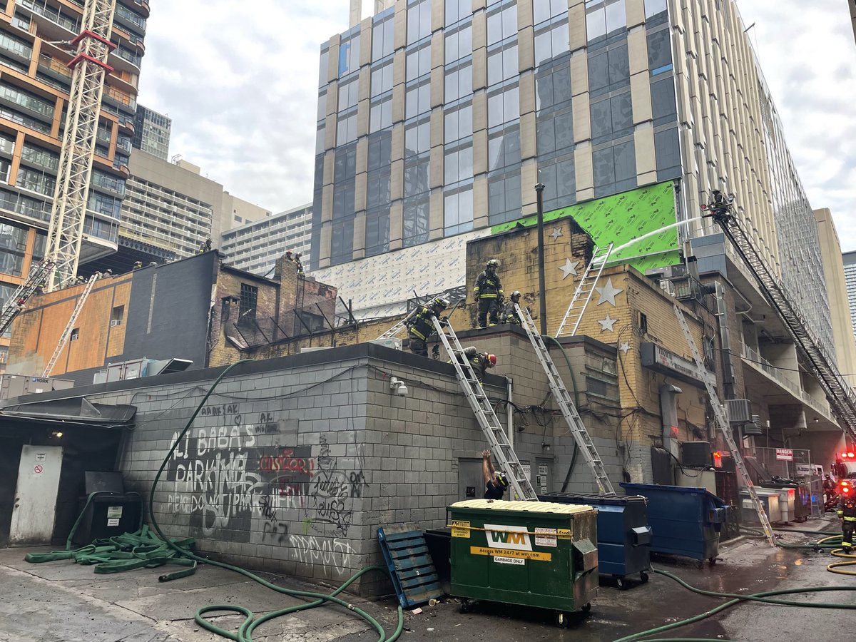 Toronto_Fire's tweet photo. TFS on scene of a 3-Alarm fire on Yonge Street, downtown at Elm Street. Crews responded for a fire on the roof and arrived to heavy black smoke. Crews are actively fighting fire with areas of the structure now deemed compromised.  No reported injuries. #toronto ^dc https://t.co/4oiDtrIaB7