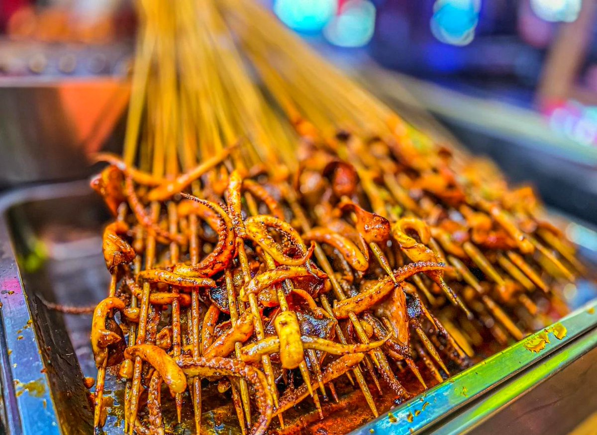 StarScaffoldLtd's tweet photo. [Perfect midday street snack: crispy fried squid skewers with spicy chili flakes—crunch on every bite! ]， https://t.co/O3QgYgXm1h