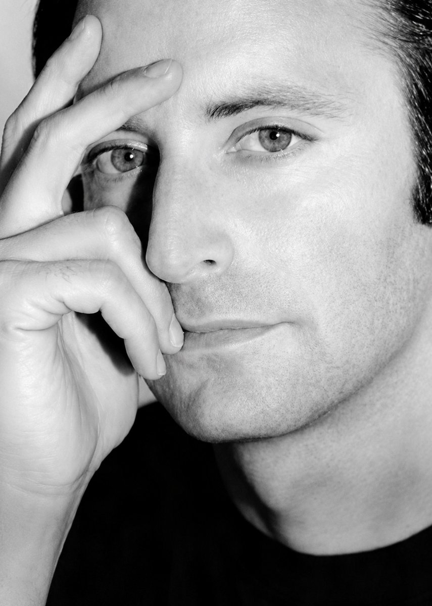 jmlx_john2's tweet photo. Herb Ritts (b. 13 August 1952) was an American fashion photographer and director who helped define the visual culture of the 1980s and 1990s. Based out of Los Angeles, Ritts bypassed traditional studio backdrops in favor of the California sunlight, desert, and ocean. His signature aesthetic combined a stark minimalism with clean lines and strong, sculptural forms which bridged the gap between fine art photography and high-fashion advertising campaigns.

Herb’s ascent began by chance in the late 1970s when he took a series of informal portraits of his friend, a then-unknown Richard Gere, at a San Bernardino gas station where they had stopped to fix a flat tire. The spontaneous shots of the sweaty, jean-clad Gere were published in Vogue, Esquire, and Mademoiselle, turning Gere into a sex symbol and Ritts into a much sought after photographer. He went on to capture defining images for the era's biggest superstars, shooting magazine covers for Vanity Fair (nearly 40), Vogue, GQ, and Rolling Stone alongside advertising campaigns for Calvin Klein, Chanel, and Gianni Versace.

Among his most recognizable photographs are -- Fred With Tires (1984), the True Blue album cover for Madonna (1986), Jump (1987), Mark Wahlberg (1992 - for Calvin Klein’s men’s underwear campaign), and the 1993 Vanity Fair cover featuring Cindy Crawford and k.d. lang.

In 1989, Ritts seamlessly moved into directing with a number of highly stylized music videos and over 50 television commercials. His videos for Madonna ("Cherish"), Janet Jackson ("Love Will Never Do (Without You)"), Chris Isaak ("Wicked Game"), and Britney Spears ("Don't Let Me Be the Last to Know") are celebrated for translating his signature high-contrast photographic look to the screen.

Raised in an affluent Brentwood family next door to actor Steve McQueen, Ritts was self-taught, having studied economics and art history at Bard College. At Bard, he realized he was gay and came out to his parents, both designers, who were accepting and supportive of his sexuality. From 1996 until his death in 2002, Herb was in a relationship with entertainment lawyer Erik Hyman.  A deeply committed advocate for HIV/AIDS funding, Herb Ritts passed away at age 50 from AIDS-related complications. 🏳️‍🌈

[Herb Ritts Self-portrait 1998; Jump (Beach Bums) 1987]