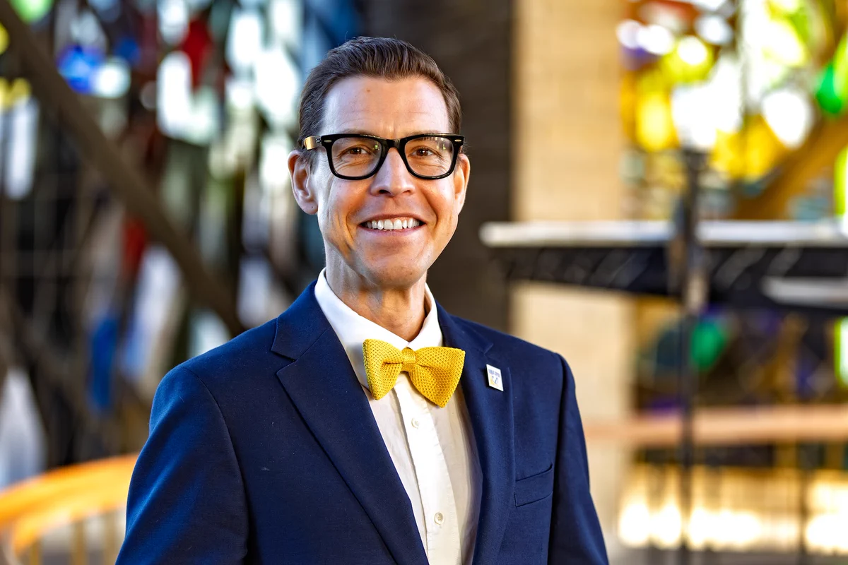 Valparaiso University's 20th president, Rev. Brian E. Konkol, Ph.D., smiling in front of the stained glass of the Chapel of the Resurrection.