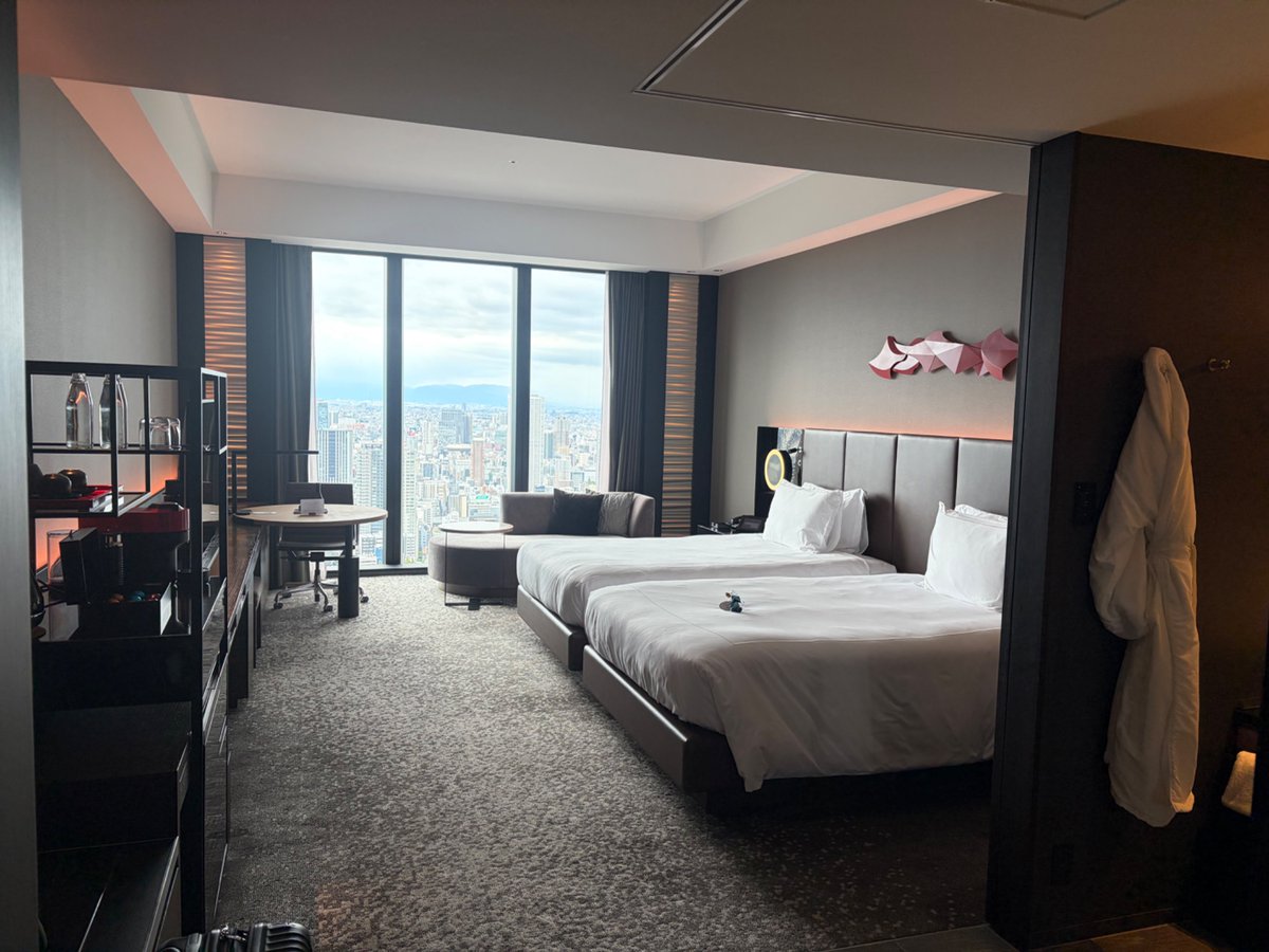 dragoninvest1's tweet photo. リッツ・カールトン大阪からチェックアウトし、そのまま「コンラッド大阪」へ移動。
地上40階のレセプションからエグゼクティウラウンジへ案内され、足を踏み入れた瞬間——
「お待ちしておりました、〇〇様」
え、まだ名前名乗ってないのになんで知ってるの…？（恐怖レベルの神連携）
ラウンジでのチェックインでは、かなり美人なスタッフの方から「お誕生日おめでとうございます！」と笑顔でお祝いいただき、なんチャッてヒルトンダイヤ💎にもかかわらず、ダイヤモンドメンバー様で、誕生日の滞在ありがとうございます。最上階のお部屋にアップグレードさせていただいておりますとのこと。レイトチェックアウトは、無理しない範囲でお願いしますと伝えたところ、リッツと同じく13時までに。
とにかく、前日との凄まじいホスピタリティギャップに、同行していた娘も「すごっ…！」とドン引き＆大興奮笑
やっぱりコンラッド大阪の特別感とVIP待遇は、国内でも頭ひとつ抜けてる。
みなさんは「名前で呼ばれてビビった神ホテル」の体験ってありますか？リプで教えてください👇