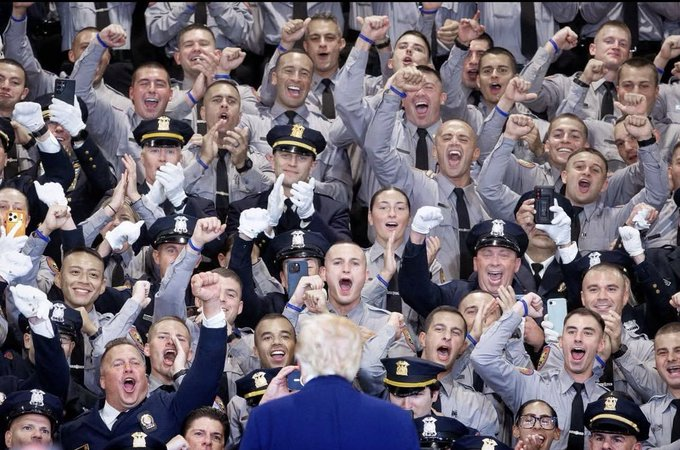 YourAnonNews's tweet photo. You should be terrified of this image of cops cheering Trump.  Why? Because it's a reassurance that they protect the criminal Epstein class and could give a shit about you. They serve and protect the corporations and billionaire pedophiles, not you. https://t.co/q1ctufh104