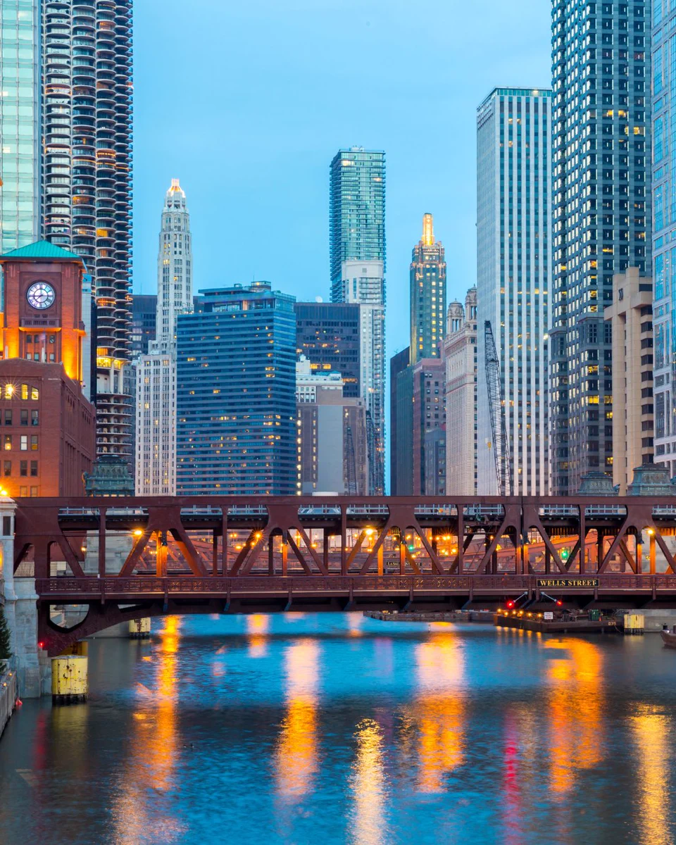 Image of Chicago river skyline showing buildings and a bridge at night.