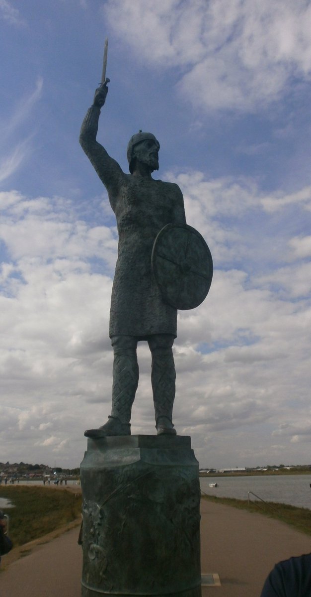 ifonlytheylist's tweet photo. Statues of Saxon Warrior Byrhtnoth on the Maldon promenade looking over to Northey island where the battle took place and also on the outside of the church on the High Street.

Ealdorman Byrhtnoth's army, which fought at the battle of Maldon, was mainly a militia force from Essex. At most perhaps 3-4,000 strong, it was raised following the Viking attack on Ipswich and marched to challenge the Viking forces as they advanced on Maldon. It is believed that the Viking boats landed on Northey Island to the east of Maldon and that the East Saxon army cornered them there. But it was high tide and so there was a shouted negotiation where Byrhtnoth refused to pay the invaders to depart but rather challenged them to battle.

As the tide fell the Viking force attempted to cross the causeway but a small band of Saxons held them back. Needing to bring the enemy to battle and defeat them, if he was to protect East Anglia from further destruction, Byrhtnoth withdrew and allowed the Vikings to across to the mainland. Formed up in a shield wall the Saxon army waited for the Viking advance. First the bowmen fired their arrows and then the rest of the infantry let fly spears as the enemy came closer. Finally they were locked into hand to hand fighting, thrusting with spears and slashing with swords.

The battle turned against the Saxons when their leader was killed. Once they realised their commander was dead most of the army seems to have fled to the woods behind them. But Byrhtnoth’s own retainers fought on to revenge his death, killing large numbers of the enemy before they too were cut down. So many of the Vikings were killed that, though they were victorious, they did not attack Maldon and indeed are said to have had trouble even manning all their boats to leave.