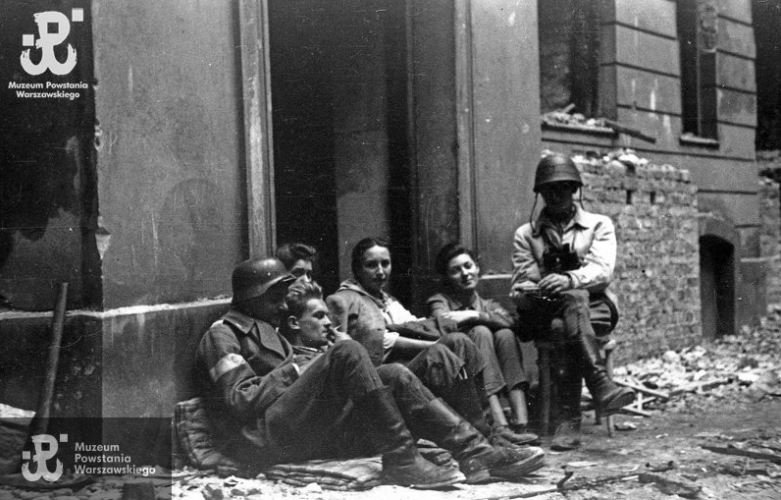 WarsawRising44's tweet photo. There is something CINEMATIC in this photograph. Look at the young man carelessly smoking a cigarette and the lady with a dreamy look. They both survived (Tadeusz Jędryka “Adam” and Jadwiga Wróblewska “Oktawia”). A scene was captured by Andrzej Bargiełowski „Stańczyk” in the #WarsawRising1944.
#ThereWasACity🔹https://t.co/0oksJkUm77