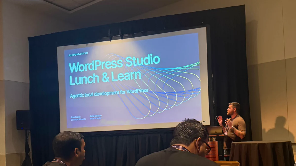 A person stands at a podium in front of a screen that says, "Automattic: WordPress Studio Lunch and Learn. Agentic local development for WordPress."