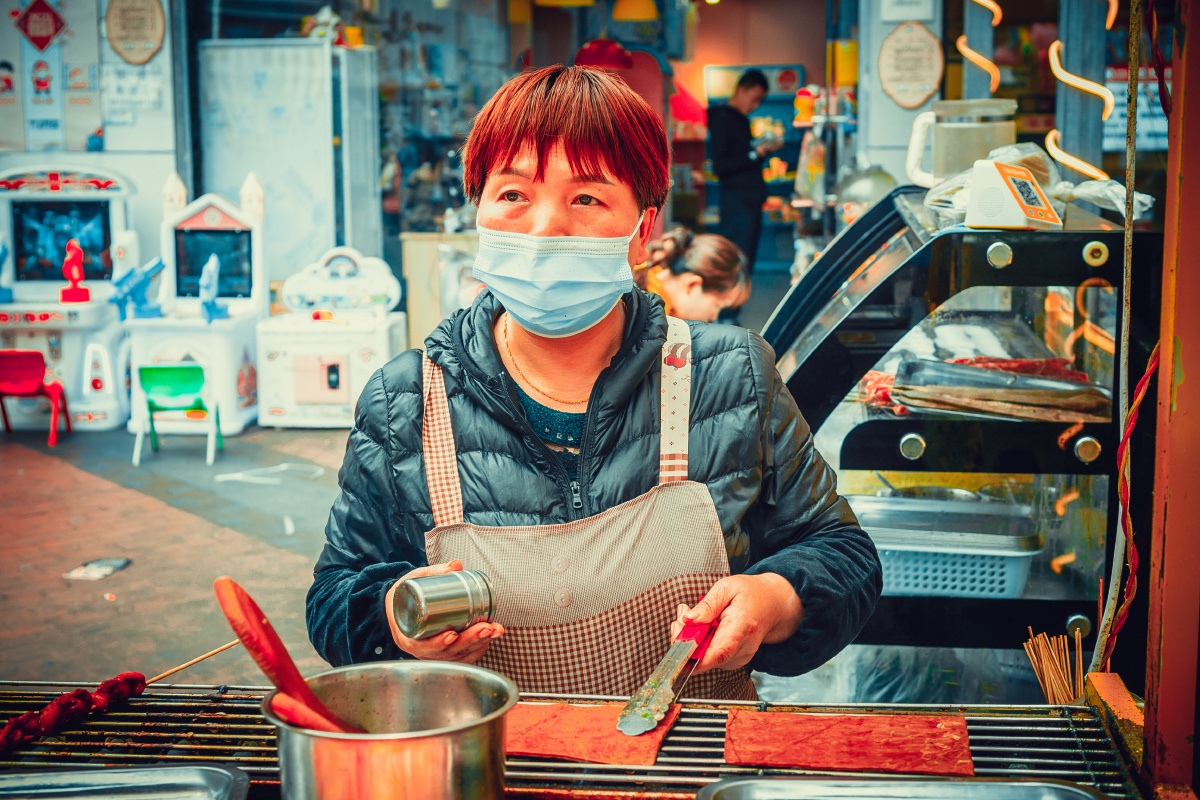 Guispee119847's tweet photo. Bustling city sidewalk vibes—got lucky with this candid mid-shot of a vendor handing a wrapped snack to a masked regular, golden hour light hitting just right. https://t.co/wa9deWjKsI