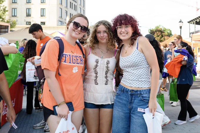 Three students posing for a photo at the Welcome Back Festival.