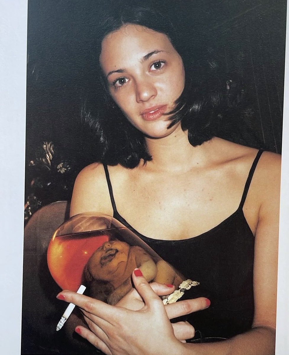 PizzaGateX's tweet photo. "Madonna and child". Asia Argento and yes, Leonardo DiCapro holding Joe Coleman's "Pickled punk"

"Ay, Joe Coleman!" So I turned around and I see this old guy by this sideshow, next to some banners "'Ay, Joe!" I come over to him and he says: ''Ay, you wanna buy a pickled punk?" I knew that a "pickled punk¿ is Carney. Carney is slang used by guys who work at a carnival. A pickled punk is Carney slang for a baby, a deformed baby in a jar. So I knew what he was saying. It sounds interesting and he takes me behind this canvas banner and he pulls out little Junior over here. And of course I fell in love with him as soon as I saw him and I paid the man exactly whatever he wanted and I took little Junior home on the subway of course, we got a lot of stares and Junior has had an honored place ever since. He is like my alter ego, he's my son. It's funny because he represents a more positive or optimistic side of my personality. That deformed little guy there he's so happy."