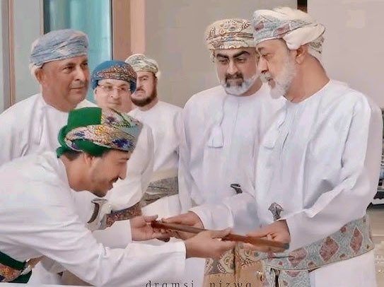 AlsiyabiHamood's tweet photo. عند “الرينج روفر” العسكرية 
الطلاء … والسيحية الاطلالة
——————————
 حمود بن سالم السيابي 
——————————-
 هنا بعض حلمك.
على بُعْد شجيرات في سيح البركات.
وحيث يصل ظلُّ بيرقك على سارية حصن الشموخ
أمشي بتؤدة رفقة مازن لكيلا تطأ الخطوات الظل.
يقتربُ شابٌّ ليخبرني بأن العصا إن لم تكنْ للاتكاء الصحي فهي ممنوعة ، فقلت له للتوازن فانْحَنَتْ ابتسامتُه. 
استفتحتُ التجوال بالتوقُّف عند "الرينج روفر" العسكرية الطلاء والسِّيحية الاطلالة فتخشَّبتْ الوقفةُ لهيبتك ، حتىى وأنت لستَ فيها لأنك فينا. 
لعل هذه "الرينج روفر" أكثر نفائس المتحف تكراراً في كاميرات الزائرين ولذلك أمطرتُها بديمةٍ من هاتفي إلى أن خشيت على ما تبقَّى من اتساع في الذاكرة ومن مساحة في الشاحن وهناك الكثير الذي يستحق التصوير. 
احتوتني الممرات التي تبرق كعهدك فاندفعتُ مع الحشود التي جاءت دونما اكتراث للعصور الجيولوجية السحيقة ولا للأزمنة الجليدية والمطيرة ، لأنك نيْزكها الأهم الذي تفلّتَ من السماء ليستقر في بؤبؤ العين.
تأنَّق المتحفُ الباذخ بقاعاته التي تشعرنا بالفخر بأن مثل هذا الصرح في بلادنا ، وأنه يذكرنا بك.
هنا الأمس البعيد جدا جدا جدا ، ولكنني لست بالجيولوجي لأغرق في الفوارق بين جبال الحجرين الشرقي والغربي ، ولا في الفوالق الصخرية بين الأخضر الأشم وسمحان. 
لقد توقفتُ طويلاً عند نهر المداد في مخطوطات الأوائل فحمدتُ الله أن النهر ما زال يجري.
واقتربتُ بعيني المتعبتين لأتواصل مع أزمنة الرسائل المتبادلة وشكرت الله أن الوطن بنفس الحميمية مع سعاة البريد وإن تغيَّرتْ التعاريف إلى وسائط ألكترونية في عصرنا الرقمي.
وكانت بوابة النهضة في متحف عمان عبر الزمان هي المحطة الأزهى ، ربما لأننا عشناها وأن ما سبقها قرأناه. 
وربما لأنك فيها تتكرر على كل شبر من الخارطة وعلى كل دقيقة من نصف القرن.
تكوَّمْتُ على أريكة جلدية مع الذين افترشوا القطيفة الموشَّاة بنصف القرن لينصتوا لبوحك تتلو البيان الأول وبيان النصر ، فالبيان تلو البيان. 
هنا لقطات لك وقد اكْتَسَتْ بزعفران السيوح فالتهبَ التصفيق.
وهنا مطاياك الخضراء التي خبَّتْ بك بين هدبة وهدبة فتعالى الهتاف.
وهنا بزاتك العسكرية بلون الوطن وإن تعددت ألوان المناسبات فوقف الجميع للسلام السلطاني.
وهنا صفحة لجريدة عمان وأخرى لجريدة النجاح ، إنه الوعد بحياة تواكب العصر في شطري الوطن الآسيوي والأفريقي فأقف كطالب مدرسي يزور الجريدة لأجل صورة للذكرى تستقر في هاتفي تحمل رائحة الورق وحبر الطباعة وزيوت المطابع.
وهنا أروع أمثلة الوفاء لمولانا الهيثم المعظم الذي أشْرَفَ شخصيَّاً على حلمك ليزهر كما تمنَّيته أنت ، وتكاملَ كما تمنَّاه هو.
ولقد كان الافتتاح تحت رعايته السامية بهيَّا وفخما ، وكنتَ الحاضر في الشوق وفي الكلمات.
ولعل عصا مولانا الهيثم المعظم هي الأيقونة النفيسة بالمتحف والتي ستتكرر في التصوير مع سيارتك العسكرية الطلاء والسيحية الاطلالة.
وبعد طول تطواف لا يُمل جرجرتُ خطى الختام وأنا أتمهَّل في ألّا تلمس عصاي الرخام لكيلا أجرح البريق واللون.
وعند البوابة الخارجية للصرح الشامخ كان سيح البركات من جديد بشجيراته الشاهدة على من مرُّوا.
وكان البيرق على سارية حصن الشموخ يمدُّ نطاق الظل إلى ما بعد بعد بعد السيح.
إنه بعض حلمك وقد عشناه. 
————————
مسقط في السادس من أغسطس ٢٠٢٣م.
ويذكرني به الفيسبوك فأعيد النشر.