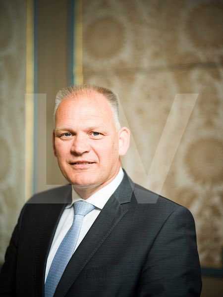roaldcs's tweet photo. Dit is Gert-Jan Buitendijk, de man die u waarschijnlijk niet kent, maar die meer continuïteit en invloed heeft dan menig minister.

Hij is secretaris-generaal van Algemene Zaken, voorzitter van het wekelijkse overleg van de hoogste ambtenaren van alle ministeries, voorzitter van het hoogste ambtelijke EU-overleg en coördinator van de inlichtingen- en veiligheidsdiensten. Ook heeft hij invloed op de procedures waarmee nieuwe topambtenaren worden geselecteerd.

Wie zoveel bestuurlijke wegen beheerst, hoeft nooit op een stembiljet te staan om richting te geven. Kortom, de bestuurlijke capo di tutti capi van Nederland.

Geen maffiabaas natuurlijk. De maffia heeft geen ministerie, geen dienstauto met chauffeur en geen rijksbreed programma voor de duurzame versterking van de samenhang binnen het afpersingsproces.

Voor de kabinetsformatie stuurde Buitendijk namens de gezamenlijke secretarissen-generaal aanbevelingen naar de informateur. Later schreef hij tevreden dat veel elementen daarvan in het regeerakkoord waren beland. De ambtelijke top helpt dus de plannen formuleren, ziet ze politiek bekrachtigd en biedt vervolgens aan dezelfde plannen uit te voeren.

De “democratie” mag ondertussen de koffie verzorgen tussen de bedrijven door.

Nu is mijn libertaire analyse zeker niet alleen dat Buitendijk nooit gekozen is. Alsof 76 Kamerzetels politici plotseling het morele recht geven om vreedzame mensen te commanderen, hun eigendom af te nemen en hun samenleving vanuit Den Haag grondig te verbouwen.

Verkiezingen veranderen dwang niet in toestemming/instemming.

Buitendijk laat vooral zien waar de werkelijke continuïteit van de staat zit. Ministers verschijnen op televisie, beantwoorden Kamervragen en verdwijnen na enkele jaren naar Brussel, een adviesraad of het met de polderstaat verweven bedrijfsleven. De permanente bureaucratie blijft zitten met de sleutels van het pand.

Zij spreekt over maatschappelijke opgaven, transities, regie en resultaatverplichtingen. Alsof Nederland een machine is en burgers onderdelen zijn die deskundige handen op de juiste plaats kunnen schroeven.

Dat is de maakbaarheidsgotspe.

Kennis over prijzen, behoeften, risico’s en mogelijkheden zit verspreid over miljoenen mensen. Geen vergadering van topambtenaren kan die kennis verzamelen. Zonder vrije prijzen, winst, verlies en concurrentie weten centrale planners niet of zij waarde creëren of vernietigen. Zij beschikken slechts over modellen, memo’s en het belastinggeld van anderen.

Wanneer hun model botst met de werkelijkheid, moet de werkelijkheid zich aanpassen.

Een onderneming die stelselmatig faalt, verliest klanten, kapitaal en uiteindelijk haar bestaan. Een ministerie dat faalt, krijgt een onderzoekscommissie, extra bevoegdheden en meer geld om de gevolgen van zijn vorige oplossing te herstellen.

Ook de transparantie is voorbeeldig Haags. Het belangrijkste ambtelijke overleg kent geen openbare agenda’s of notulen. De Woo wordt behandeld als een hinderlijke systeemfout waardoor burgers soms ontdekken wat hun overheid met hen heeft bedacht.

Zo groeit tunnelvisie vanzelf. Iedereen aan tafel onderschrijft diversiteit, zolang niemand het geloof in centrale sturing ter discussie stelt. De ene planner wil drie taskforces, de andere vijf. Maximale pluriformiteit in het aantal commissies.

De burger kan niet opzeggen, geen concurrent kiezen en zijn belasting niet terugvragen. Achter iedere vriendelijke beleidsbrief staat uiteindelijk een boete, deurwaarder of politieagent.

Buitendijk is daarom zeker niet het probleem, maar het perfecte symbool van de autocratische Bobo Polder.

Politici verkopen ons de illusie dat wij de staat besturen. De capo zorgt verkiezing na verkiezing dat de staat ons blijft besturen, los van de uitslagen.