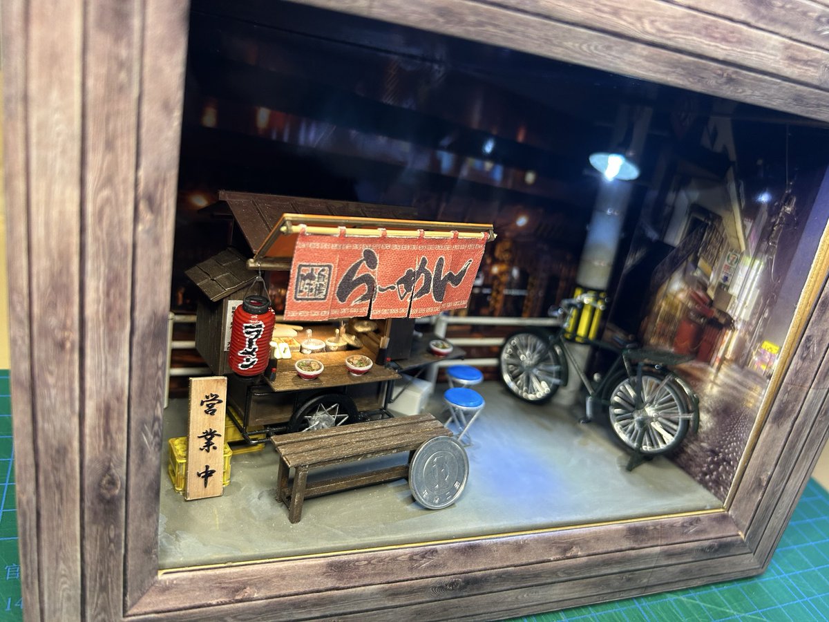 TOY_STEP1's tweet photo. 本日、完成した　久しぶりに屋台を作った　スケールは1/25 LEDも取り付けて　それなりの雰囲気ができた　ガチャガチャであった　ネコ店主も置いてみた https://t.co/Fzqd5g9uCv