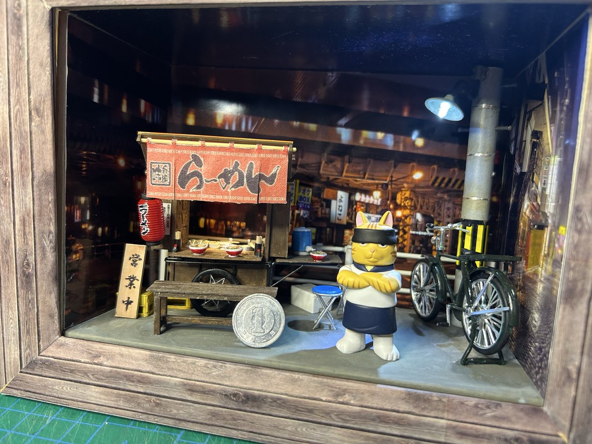 TOY_STEP1's tweet photo. 本日、完成した　久しぶりに屋台を作った　スケールは1/25 LEDも取り付けて　それなりの雰囲気ができた　ガチャガチャであった　ネコ店主も置いてみた https://t.co/Fzqd5g9uCv