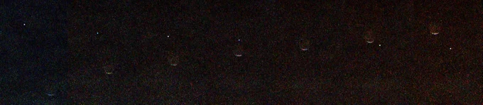 A series of images taken over the course of a few minutes that show the lumpy moon Phobos passing in front of a blue star that is Earth in the sky.