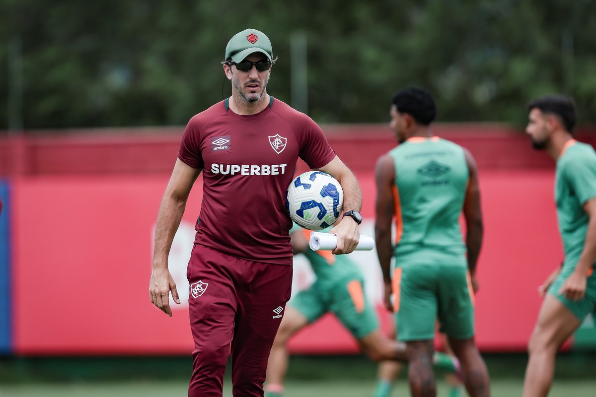 Victorg_Lessa's tweet photo. O trabalho do Zubeldia acabou, e os responsáveis por mantê-lo no cargo o farão de forma paliativa, sabendo que se trata apenas de uma questão de tempo. E, com isso, vão tirar o Fluminense da principal competição do calendário.

O trabalho não acabou pela eliminação de ontem. O que vimos no Maracanã foi apenas mais uma manifestação irrefutável e 100% crível do time comandado por Luis Zubeldia: covarde, frouxo, medroso e inseguro. Ele não é técnico para clube grande e, de fato, isso já tinha sido avisado. Praticamente todos os elementos que o fizeram sair do São Paulo estão presentes em seu trabalho no Fluminense.

Péssima leitura de jogo, indecisão nas substituições, refém dos veteranos e perebas contumazes, rival da base, sempre reativo e apequenando o time em jogos decisivos. Falei sobre isso não faz muito tempo. Quando uma equipe é moldada na coragem, provavelmente, quando perder, o fará fazendo merda pelo simples fato de não admitir a derrota e se arriscar.

Mas quando o time é moldado na covardia, na insegurança, na indecisão, é quase impossível virar essa chave justamente em jogos decisivos como o de ontem. A mente está condicionada a se diminuir, não a crescer diante das dificuldades. Uma mentalidade fracassada leva, cedo ou tarde, ao fracasso esperado.

Os sinais de declínio no trabalho vêm de muito tempo. A classificação do Fluminense na Libertadores foi um acaso. Já era para ter caído ali. Mesmo diante do que foi apresentado, a diretoria do Fluminense seguiu com a convicção de que o trabalho tinha futuro. Mas o time piorou e piorou em todos os aspectos: físico, tático e técnico.

Creio que pouca gente está dando a devida importância a isso, mas me parece que a preparação durante a Copa do Mundo foi um lixo, e o campo escancarou isso. Lesões aos montes e um time em baixa rotação. O Vasco fez o DOBRO de faltas e no corpo a corpo ganhava a maioria das divididas. O Fluminense faz uma pressão no início do segundo tempo e depois morre, se arrasta nos acréscimos.

As opções para virar o clássico foram Ganso, Cano e Hulk. Isso já explica muita coisa. Por sinal, Ganso não servia para jogo nenhum, ou não poderia entrar em campo, mas ontem, na hora do desespero, voltou a ser opção. Pedimos centenas de vezes a mudança de esquema tático. Com pontas jogando nada, era o momento de tentar algo diferente. Teve dois amistosos, dois meses de preparação, e resolveu fazer quando tudo já tinha desandado.

Técnico bom se adapta, repensa, arrisca, testa coisas diferentes. Técnico medíocre tem medo de sair da zona de segurança, tem preguiça de pensar além, e essa mediocridade te leva, não demora muito, para a vala da derrota. Se perdeu completamente e está evidente que não sabe mais o que fazer.

A partir de agora não vou perder tempo em falar de Zubeldia como ator principal de mais outros fiascos que vêm por aí. A responsabilidade será inteiramente de quem o mantém por lá.

Foto: Marcelo Gonçalves / Fluminense FC