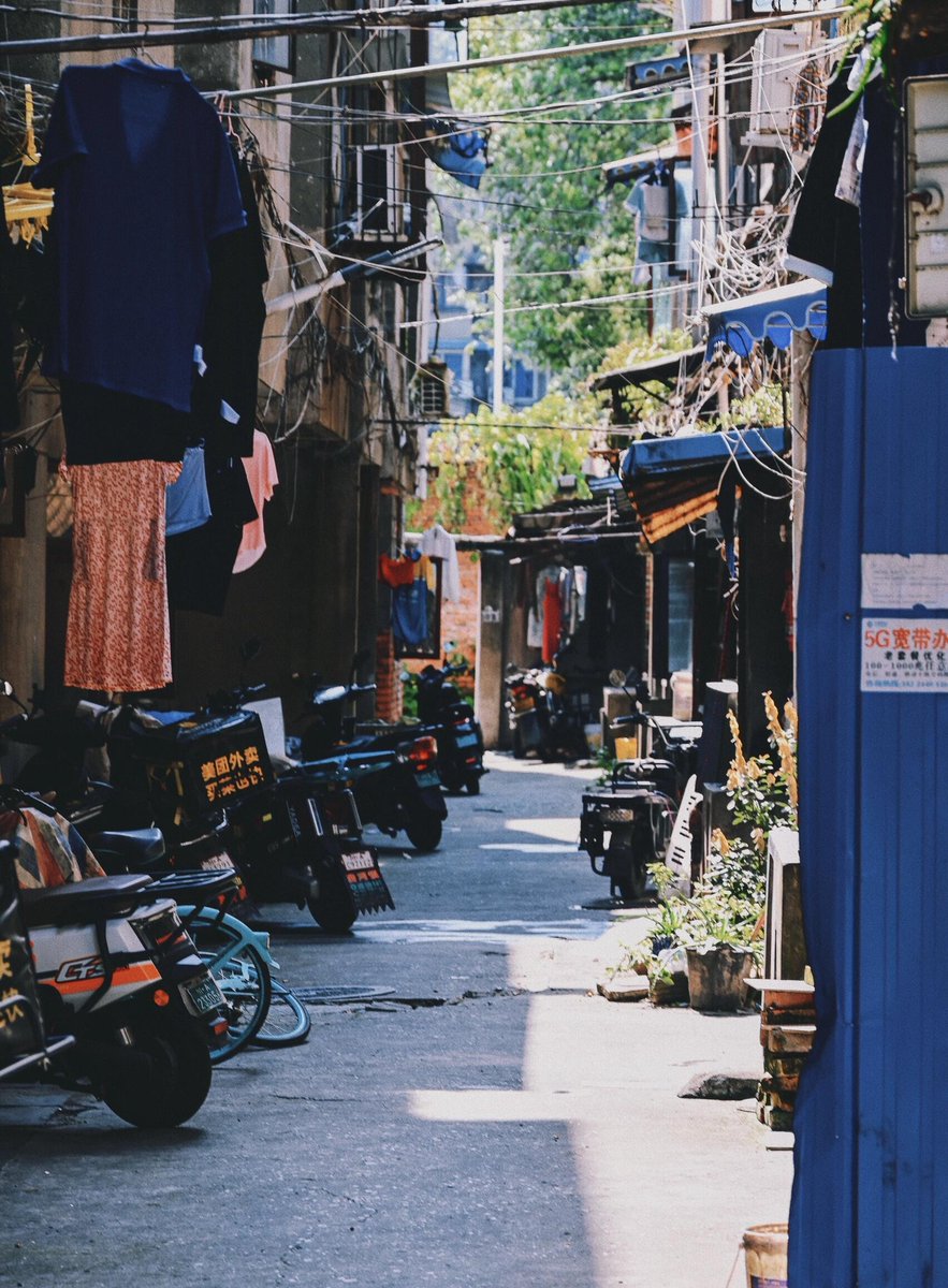 CoraHamletnpyj's tweet photo. Golden hour glows on this quiet alley corner—local vendors sharing laughs, bikes leaning against brick walls, and the city’s small, warm moments. Street life hits different here. https://t.co/hruPST3UEe