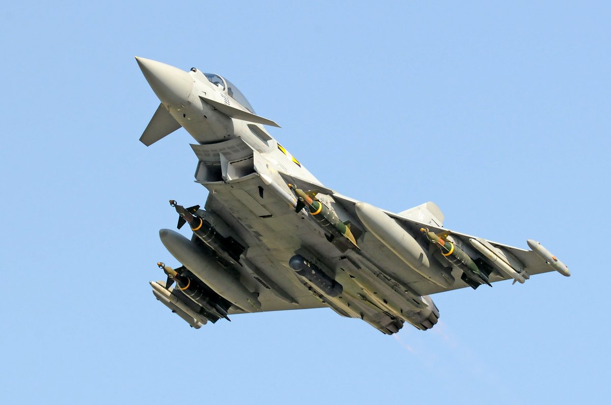 MichaFiszer's tweet photo. Eurofightery nad Libią 2011 r. - cz. 2

Uderzenia NATO sprawiły, że system obrony powietrznej Libii bardzo szybko przestał istnieć. Jego poziom sprawności był jednak bardzo niski. Większą wartość bojową przedstawiał jedynie dywizjon wyposażony w przeciwlotniczy zestaw rakietowy dalekiego zasięgu S-200, który został szybko zniszczony. W końcu marca rządowe siły libijskie nie miały do dyspozycji już żadnej stacji radiolokacyjnej kontroli przestrzeni powietrznej, a najdłużej pracował cywilny radar w Porcie Lotniczym w Trypolisie, choć kiedy planiści z NATO zorientowali się, że podaje on informacje do systemu obrony powietrznej Libii, także i on został wyeliminowany. Wkrótce zniszczono też większość dywizjonów przeciwlotniczych dwóch libijskich brygad rakietowych obrony powietrznej: 32. Brygady (dowodzonej przez Chamisa Kadafiego, syna dyktatora) i 77. Brygady, broniących wybrzeża państwa.

Mimo, że początkowo obawiano się libijskich samolotów myśliwskich MiG-23 stacjonujących w Metiga pod Trypolisem, to jednak do walk powietrznych z nimi nie doszło. Dowódca brytyjskiego kontyngentu lotniczego, gen. dyw. (Air Vice Marshall) Greg Bagwell ogłosił już 23 marca, że Siły Powietrzne Libii praktycznie nie istnieją, to jednak pewne obawy o możliwość konfrontacji nadal istniały, piloci samolotów Typhoon byli więc przygotowani do ewentualnych realnych walk powietrznych. 
Początkowo samoloty wielozadaniowe Typhoon były używane wyłącznie do działań w ramach wymuszania strefy bez lotów oraz do eskortowania własnych maszyn rozpoznawczych lub uderzeniowych. Pierwszą misję bojową trwającą około 5 godzin z trzema tankowaniami w powietrzu wykonała para prowadzona przez dowódcę dywizjonu Typhoonów w Goia del Colle, a zarazem dowódcę 11. Dywizjonu RAF, ppłk. Jeremy „Jez” Attridge (obecnie w stopniu generała brygady – Air Commodore – jest brytyjskim attaché lotniczym i kosmicznym w Stanach Zjednoczonych). Po misji ppłk Jez Attridge powiedział prasie: Typhoony RAF są zaangażowane każdego dnia w misje operacyjne w Wielkiej Brytanii, chroniąc przestrzeń powietrzną państwa przed naruszeniami. Dlatego tutejsze misje nie różnią się zbytnio od sposobu, w jaki normalnie działamy i trenujemy. Dla mnie była to tylko kwestia kontynuowania dobrze mi znanych działań.

Jednak 12 kwietnia 2011 r. po raz pierwszy dwa Typhoony uzbrojone w kierowane bomby lotnicze GBU-49 Enhanced Paveway II (kierowane satelitarnie i laserowo, wagomiaru 500 funtów, czyli 227 kg) towarzyszyły dwóm samolotom myśliwsko-bombowym Tornado GR.4 przenoszącym kierowane bomby lotnicze Paveway IV (kierowane laserowo, wagomiaru 500 funtów, czyli 227 kg). We wspólnym ataku w rejonie miasta Misrata, które było otoczone przez siły rządowe, zniszczono osiem czołgów T-72.

Do kolejnego takiego ataku pod Misratą doszło 18 kwietnia. Mimo, że samoloty wielozadaniowe Typhoon też przenosiły optoelektroniczne zasobniki obserwacyjno-celownicze Litening III, to laserowe podświetlenie celów dla ich bomb realizowały za pomocą zasobników tego samego typu samoloty Tornado GR.4. Dwuosobowa załoga tych ostatniego pozwalała bowiem, by robił to nawigator-operator systemu uzbrojenia z drugiej kabiny, przez co wybór celu i przejście na jego śledzenie odbywało się pewniej. Tego dnia celem ataku bombowego były artyleryjskie wyrzutnie rakietowe BM-21, z których ostrzeliwano opanowane przez rebeliantów miasto Misrata.

Do końca kwietnia siły powietrzne koalicji zniszczyły na ziemi 176 czołgów, 108 innych pojazdów pancernych i 50 dział artylerii polowej. Jednak wojska rządowe szybko przystosowały się do nowych warunków. Wojska działały w małych grupach i trudniej było odnaleźć zgrupowania ciężkiego sprzętu do zwalczania. Poprawiono też maskowanie. Trzeba więc było pomyśleć o zmianie sposobu działania, większą rolę przywiązać do rozpoznania prowadzonego wszelkimi dostępnymi środkami, w tym systemami bezzałogowych statków powietrznych działającymi non stop przez 24 godziny na dobę przez siedem dni w tygodniu i śledzącymi wszelkie zmiany zachodzące na obszarze zainteresowania. Jednocześnie do ataków na cele naziemne trzeba było zaangażować więcej sił lotniczych.

Szczególnie rozległe tereny wzgórz Jebel Nafusah po wschodniej stronie Libii, gdzie rebelianci nie mogli się przebić przez obronę wojsk rządowych w kierunku na zachód, do rejonu libijskiej stolicy, wymagały wielu uderzeń. Tutaj główną rolę odgrywały kontyngenty Kataru i Zjednoczonych Emiratów Arabskich, które wykonywały uderzenia samolotami wielozadaniowymi Mirage 2000 i F-16. Dodatkowo dołączyły do nich francuskie Rafale. Natomiast siły brytyjskie skoncentrowały swoje zaangażowane na wspieraniu z powietrza dwóch enklaw rebeliantów po zachodniej stronie kraju: Brega i Misrata. To właśnie tu głównie działały Typhoony.
Następnego ataku z użyciem bomb GBU-49 Enhanced Paveway II samoloty wielozadaniowe Typhoon dokonały 12 maja 2011 r. już samodzielnie, kiedy to w pobliżu Syrty zniszczono dwie haubice samobieżne Palmaria kal. 155 mm (włoskiej produkcji, zakupione przez Libię w 1982 r.). 25 maja doszło ponownie do wspólnego ataku Typhoonów i Tornado na park pojazdów w Taji, gdzie zniszczono sporo samochodów ciężarowych i pojazdów pancernych wojsk rządowych. 27 maja samoloty Typhoon wykonały uderzenie na obóz wojskowy Bab al-Aziziyah, niszcząc https://t.co/LLcxjx5hkG. jego wieże wartownicze.

26 i 28 czerwca 2011 r. zespoły Tornado – Typhoon ponownie uderzyły na obiekty wojsk rządowych, głównie czołgi oraz artylerię samobieżną w rejonie wzgórz Djebel Nafusa pod Trypolisem. Był to moment, kiedy rebelianci, po opanowaniu wschodniej, a następnie południowej Libii podeszli teraz do zachodniej jej części i zaczęły się walki o stolicę państwa, Trypolis. Latem 2011 r. ostatnim bastionem wojsk rządowych była centralna część państwa. W lipcu zaczęły się walki o Zlitan, które było jednym z ostatnich dużych miast na libijskim wybrzeżu, kontrolowanym przez siły rządowe.
Brytyjskie Typhoony wraz z włoskimi maszynami tego typu kontynuowały działania związane z wymuszaniem strefy bez lotów oraz osłony własnych samolotów uderzeniowych (brytyjskie) i rozpoznawczych (włoskie) w ramach misji „powietrze-powietrze”. To jest obszar, w którym Typhoony osiągnęły gotowość operacyjną w pierwszej kolejności i w czasie debiutu bojowego z oczywistych względów, skierowano je do działań właśnie tego typu. Jednakże libijskie przeciwdziałanie w powietrzu było w istocie żadne, rządowe myśliwce nie pojawiały się, bowiem ich lotniska stały się celem ataków na samym początku, a ponadto nie funkcjonował system radiolokacyjnej kontroli przestrzeni powietrznej libijskich sił rządowych. Dlatego właśnie Typhoony nie mogły się wykazać w swojej głównej roli, do jakiej zostały opracowane.

W czerwcu 2011 r. rebelianci podjęli ofensywę w kierunku enklawy Brega, ale wkrótce została ona zatrzymana. Dlatego właśnie od połowy czerwca do połowy lipca NATO zintensyfikowało swoje działania. Problemem był jednak fakt, że amerykański Kongres zabronił kontyngentowi Stanów Zjednoczonych wykonywania uderzeń na cele naziemne w Libii, bowiem prezydent Barak Obama nie poinformował go w odpowiedni sposób i w odpowiednim czasie o skierowaniu wojsk do działań bojowych. Po wstrzymaniu udziału Stanów Zjednoczonych w atakach na wojska rządowe Kadafiego, pozostałe państwa musiały więc zintensyfikować swoje wysiłki i do uderzeń lotniczych dołączyły tureckie i greckie wielozadaniowe F-16 oraz włoskie myśliwsko-bombowe Tornado i szturmowe AMX.

Dopiero w sierpniu udało się dokonać upragnionego przełomu. Ciągłe redukowanie możliwości bojowych wojsk rządowych dało w końcu rezultaty i rebelianci zdołali podjąć ofensywę na stolicę, Trypolis. 20 sierpnia zbliżyli się do libijskiej stolicy i 22 sierpnia zdołali aresztować prominentnego przedstawiciela władz, drugiego syna Kadafiego, Saif al-Islam, którego jednak zwolniono. 24 sierpnia zdobyto ważne koszary Bab al-Azizia w Trypolisie, a 29 sierpnia kontrolowano już cały Trypolis. I to był początek końca reżimu osiągnięty dzięki efektywnym i precyzyjnym uderzeniom lotniczym NATO, w dodatku w większości bez udziału Sił Powietrznych Stanów Zjednoczonych. 20 października 2011 r. rebelianci zdobyli Syrtę i ogłosili, że znaleziono tu martwego Muammara Kaddafiego. Kiedy i jak dokładnie zginął, tego się chyba nigdy nie dowiemy z całą pewnością.

Ogólnie w toku operacji „Oddysey Dawn” i „Unified Protector” samoloty wielozadaniowe Typhoon i myśliwsko-bombowe Tornado GR.4 wykonały łącznie 1114 lotów bojowych w czasie 2395 godzin, z czego około 55%, to loty tych pierwszych. Co do skali uderzeń lotniczych na cele naziemne, to Tornado wykonały 455 takich lotów, zaś Typhoony tylko 91, jako że tylko część wylotów tych ostatnich była związana z atakowaniem obiektów naziemnych. Jednak osiągnięto bardzo imponujący rezultat, aż 97% postawionych do wykonania zadań zakończyło się sukcesem.

W typowej misji uderzeniowej Typhoony zabierały: optoelektroniczny zasobnik obserwacyjno-celowniczy Litening III podwieszony centralnie pod kadłubem, dwa pociski „powietrze-powietrze” ASRAAM na zewnętrznych zaczepach podskrzydłowych, dwa pociski AIM-120 AMRAAM na bocznych zaczepach podkadłubowych, dwa dodatkowe zbiorniki paliwa na środkowych zaczepach podskrzydłowych i dwie-cztery bomby GBU-49 Enhanced Paveway II lub GBU-48 (wagomiaru 1000 funtów, czyli 454 kg) na podskrzydłowych zaczepach po bokach zbiorników paliwa. W misjach „powietrze-powietrze” zabierano cztery pociski AIM-120 AMRAAM, nie zabierano natomiast bomb.

Na zdjęciu brytyjski Typhoon po starcie z Goia de Cole we Włoszech z uzbrojeniem do ataku na Libię. 
Fot. Wikipedia

Jeśli chcecie, żebym poświęcał swój czas na te wpisy, jeśli w ogóle chcecie je czytać, to poproszę o kawkę. To tylko kilka złotych, a mnie rekompensuje włożony w tę pracę czas.  https://t.co/pPHnCSlNfq