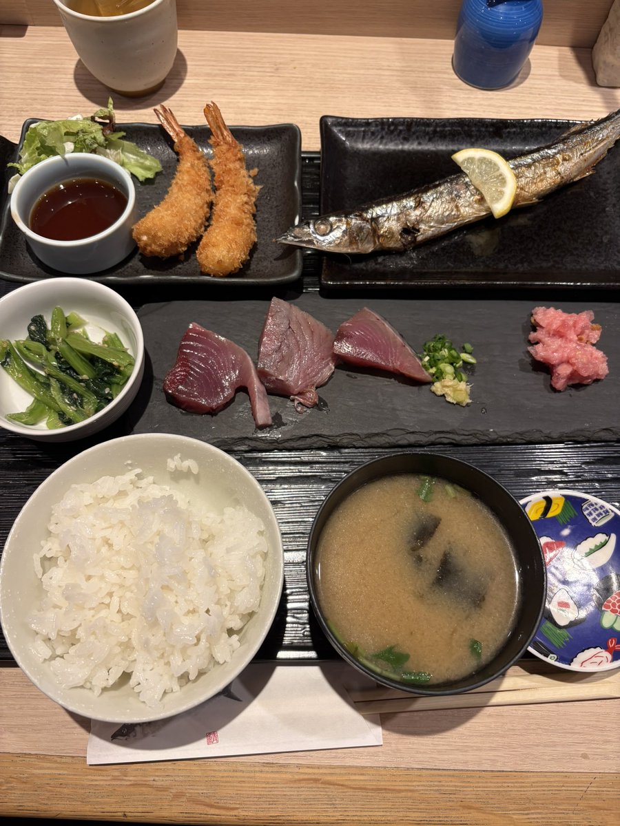 LunchTime_Quest's tweet photo. 本日乃昼餉😋

『黒さわ』@荒川区 日暮里
本日の日替り定食　¥990
・板盛り（鰹の刺身・鮪すき身）
・秋刀魚の丸焼き
・海老フライ

この内容で税込¥990は、
今日も驚きのコスパ✨

本日の板盛りは、
もっちりとした食感と
濃厚な旨味が楽しめる鰹の刺身に、
脂の甘みが広がる鮪のすき身❗️
シンプルながら鮮度の���さが際立つ一皿😋

秋刀魚は一尾丸ごと豪快に❗️
軽く丸干しなのか❓
引き締まった身にやや強めの塩味､
そして腹ワタの苦味がまぁ旨い😋
大根おろしも醤油も要らないほど、
そのままで十分旨い✨

海老フライは､
サクサク軽やかな衣の中に、
ぷりっと弾ける海老の食感🍤

ご飯は50円､味噌汁は無料❗️で
おかわりOK😋
今日も大満足の昼メシ武者修行‼️