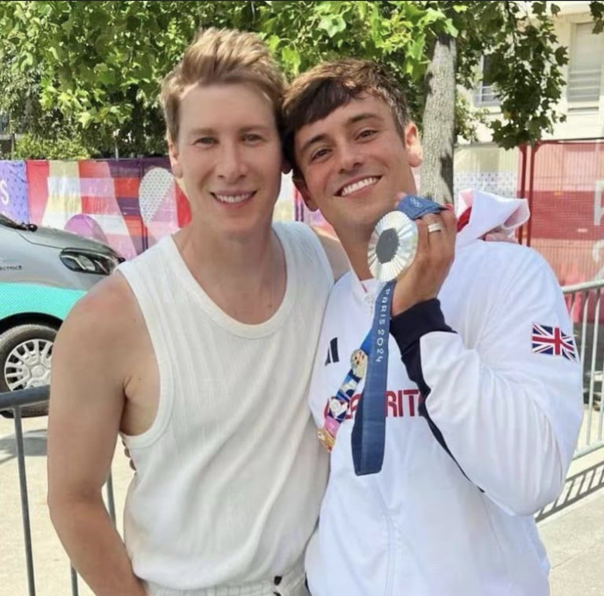 SceneOrbit's tweet photo. Tom Daley with his silver medal and husband Dustin Lance Black at the Paris 2024 Olympics. 🥈❤️ https://t.co/bJU8QVSlBS