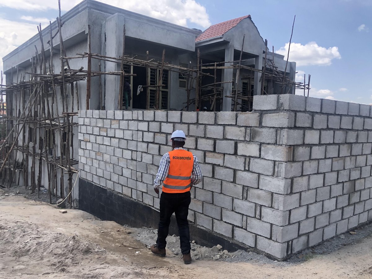ApolloBuregyeya's tweet photo. The Engineering Behind Everyday Things.
=======
Part 19: Why Do Some Boundary Walls Lean or Collapse?
=======

Building a boundary wall looks simple. Dig a foundation, lay blocks or bricks, add plaster and install a gate. That simplicity is deceptive. Unlike many walls inside a building, a boundary wall often stands alone, without floors, roofs or crossing walls to help hold it in position.

A boundary wall may carry little weight from above, but it must resist forces pushing it sideways. Wind, moving soil, water, tree roots, gates and occasional vehicle impact can all test it. The wall has no roof to hold its hand and no neighbouring wall to share the trouble.

Wind is one of the most underestimated forces. A long, solid boundary wall behaves like a sail, catching every strong gust that passes across the property. The higher the wall becomes, the larger the surface exposed to wind and the greater the leverage available to push it over.

This is why increasing a wall from two metres to three metres is not merely adding another metre of blocks. It changes how the wall behaves and may require a wider foundation, thicker masonry, closer support columns or additional reinforcement. A wall should not be promoted in height while its foundation remains on the old salary.

The foundation must spread the wall’s weight safely and prevent it from sliding or overturning. If it is too narrow, too shallow or built on soft ground, the wall may begin leaning even when the blocks themselves are strong. A straight wall above cannot remain straight for long when the ground beneath it is settling unevenly.

Problems are especially common where one section rests on firm natural ground while another sits on loose fill, an old rubbish pit or soil that was never properly compacted. The wall may have one address, but the ground beneath it can have several different histories. As the weaker section settles, cracks appear and the wall begins tilting towards the side offering the least resistance.

Supporting piers or reinforced concrete columns may be needed at suitable intervals, particularly for tall or long walls. These supports divide the wall into shorter panels and help it resist sideways forces. Their spacing and size should depend on the wall height, thickness, materials and expected loads rather than on the number of columns the owner can still afford after buying the gate.

The columns must also be properly connected to the foundation and, where required, to a reinforced beam along the top of the wall. A column that begins on top of the footing without adequate anchorage may look impressive while contributing very little. Concrete does not become structural merely because it is vertical.

A properly designed top beam can tie the wall panels and columns together, helping the entire wall act as one system. A simple mortar cap or thin strip of concrete may protect the top from rain, but it should not be confused with a reinforced structural beam. One is a rain hat; the other is a belt holding the wall together.

The quality of the masonry matters as well. Weak blocks, poorly proportioned mortar, half-filled joints and badly bonded corners create lines along which the wall can crack. Even strong blocks will not save a wall assembled with mortar that crumbles whenever it is questioned by rain.

Good workmanship requires properly arranged blocks or bricks, fully filled joints and enough time for the mortar and concrete to gain strength. Building a tall wall rapidly and loading it before the materials have hardened may leave it vulnerable from the beginning. Speed produces visible progress, but walls are not paid bonuses for reaching full height before the weekend.

Water causes several different problems. Rainwater discharged beside the foundation can soften the supporting ground or wash away fine soil particles. Blocked drains, leaking pipes and ground sloping towards the wall can keep one section permanently wet while the rest remains relatively dry.

Heavy rainfall is therefore often the event that reveals a weakness, not the original cause of failure. The rain may receive all the blame because it was present when the wall fell, but it usually found a foundation, drainage system or structural arrangement that had already prepared the opportunity.

The risk becomes much greater when a boundary wall is also expected to hold back soil. This commonly happens when one plot is filled higher than the neighbouring property or when earth is piled against the inside of an existing wall. The wall may still be called a boundary wall, but the soil has quietly appointed it as a retaining wall.

Retained soil pushes sideways, and the pressure increases when the soil becomes saturated with water. An ordinary boundary wall designed only to carry its own weight may not resist that force. Plaster, paint and confidence cannot convert it into an engineered retaining structure.

Where a wall must hold back soil, the foundation, wall thickness, reinforcement and drainage must be designed for that purpose. Water trapped behind the wall needs a safe route out because wet soil pushes harder than dry soil. The soil does not care what title appears on the drawing; it applies the same pressure to everything standing in its way.

Gate openings introduce another concentration of forces. Large steel gates are heavy, and their repeated opening, closing and occasional slamming place extra demands on the supporting posts. A wide solid gate can also catch the wind like a second sail attached to the wall.

Gate posts therefore require proper foundations, reinforcement and connections. Hanging a heavy gate from a decorative block column and optimism may work during handover photographs, but daily use eventually reviews the arrangement more honestly.

Trees can also affect boundary walls. Growing roots may lift or push foundations, while large trees can change the moisture condition of nearby clay soils. On the other hand, removing a mature tree may allow dry soil to become wetter and swell, so the relationship between trees and walls is not always solved by reaching immediately for a chainsaw.

Nearby excavation can remove support from beneath a wall, particularly where trenches, drains or new foundations are dug close to it. Soil may move towards the excavation, leaving part of the boundary foundation unsupported. Property lines may be clear on the survey plan, but moving soil has never shown much respect for land titles.

Very long walls need room to respond to temperature changes, drying and small ground movements. Without suitable movement joints, stresses build up until cracks form at weak locations. The wall may crack near columns, corners, changes in height or wherever workmanship has kindly provided a starting point.

Warning signs should not be ignored. A widening lean, open joints near the base, diagonal cracks, separating columns, bulging panels or soil washing away from the foundation all suggest that the wall needs investigation. A wall beside a road, walkway, school or occupied building deserves particular attention because its failure can endanger people who had no role in constructing it.

Plastering over the cracks does not restore stability. The foundation, wall height, thickness, support spacing, retained soil, drainage and gate loads should first be examined. Where the wall has already leaned significantly or lost support, carefully dismantling and rebuilding it may be safer than repeatedly decorating a structure that has begun negotiating with gravity.

Some boundary walls stand for decades because their foundations, materials, proportions and drainage suit the conditions in which they were built. Others lean or collapse because they were made too high, too thin, poorly supported, overloaded by soil or gates, weakened by water, or founded on ground that could not hold them evenly.

A boundary wall is not simply a row of blocks separating two properties. It is a free-standing structure that must resist its own weight and every sideways force the environment sends towards it. In Part 20, we shall examine the wall that is deliberately built to resist soil and ask: Why Do Some Retaining Walls Bulge or Collapse?