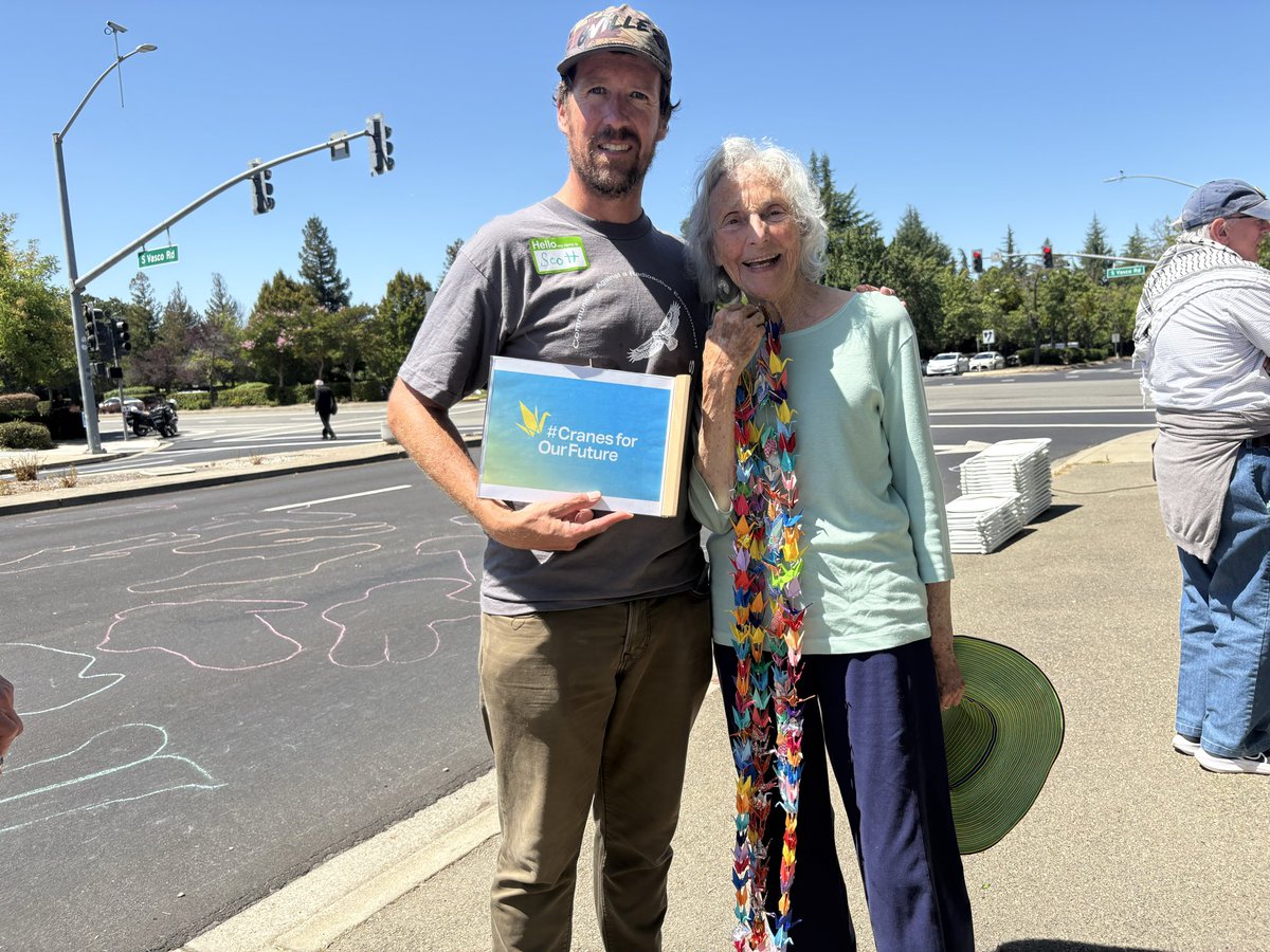 ScottYundt's tweet photo. With Patricia Ellsberg at the gates of @Livermore_Lab on August 6th, the 81st anniversary of the US atomic bombing of Hiroshima. #cranesforourfuture https://t.co/Pd1Ttr9Gcf
